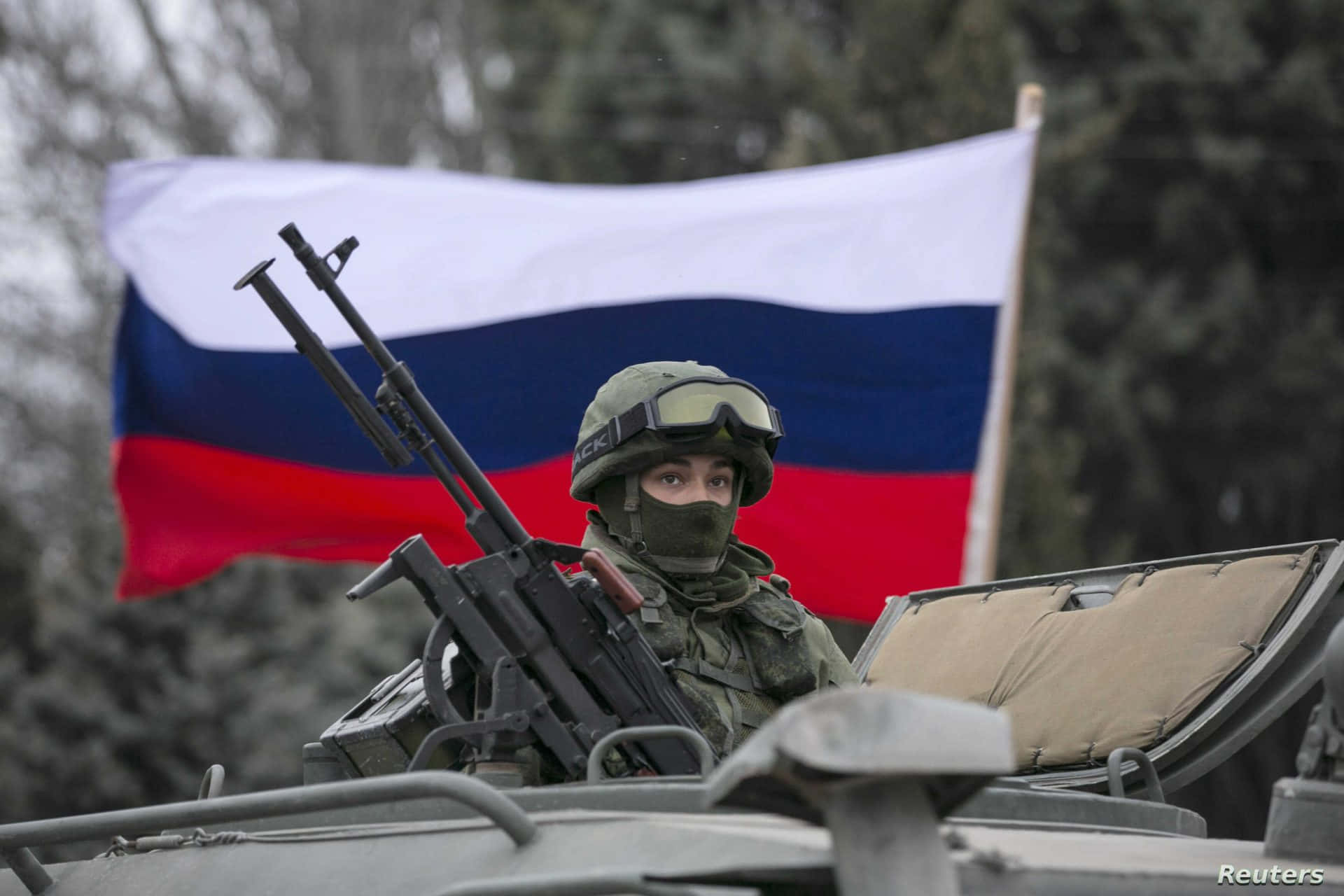 Russian 桌布 壁紙 — 一名全副武裝的士兵在軍車內手持機槍，身後飄揚著俄羅斯國旗。