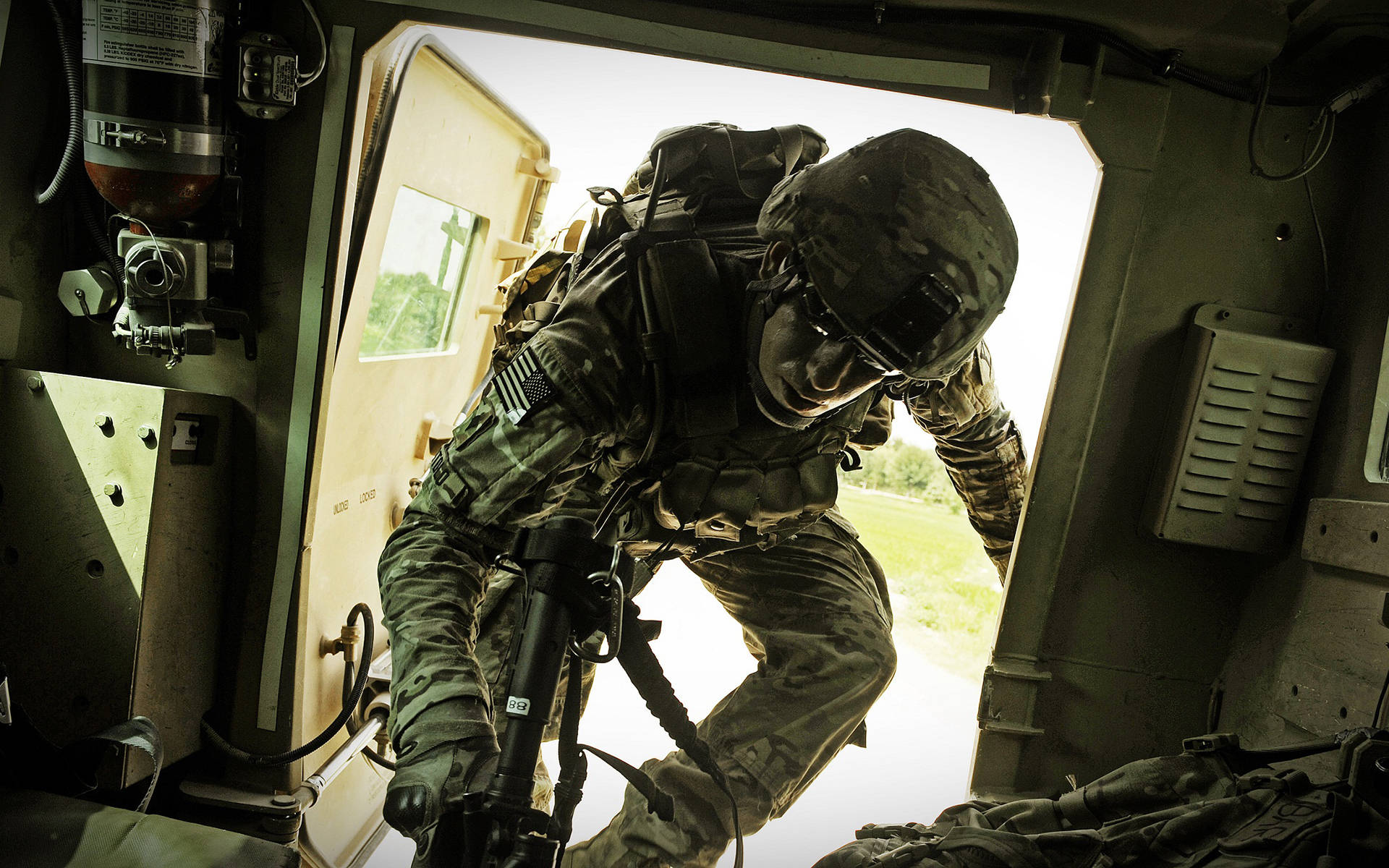 soldier 桌布 壁紙 — 一名全副武裝的士兵帶著專注的決心，在明亮的日光下離開軍用車輛。