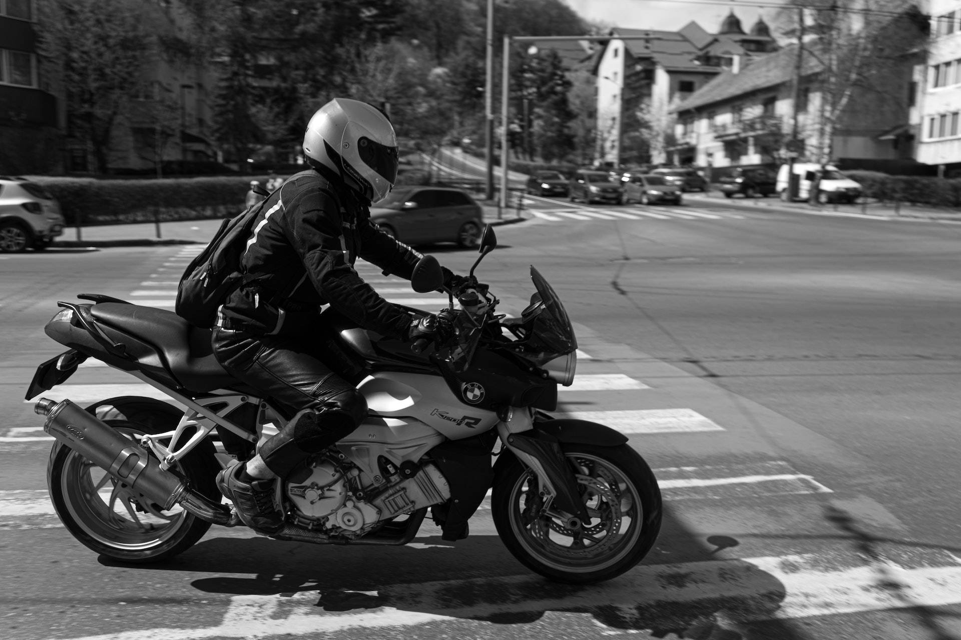 bike riding 桌布 壁紙 — 一名全副裝備的機車騎士騎乘BMW R1200R穿過住宅區一個陽光普照的十字路口。