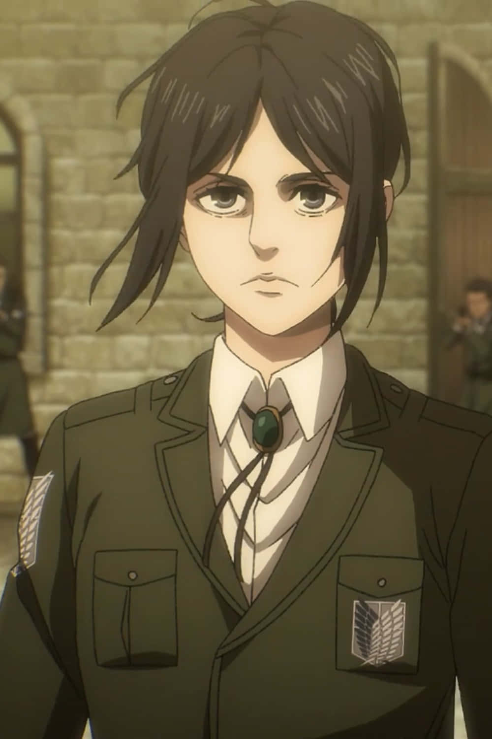 Pieck Finger 桌布 壁紙 — 一名堅定的動漫士兵，身穿綠色制服並繫著波洛領帶，站在石造建築前。