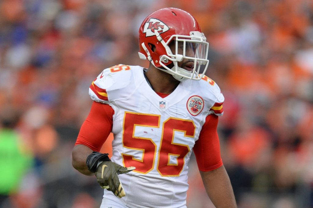 Kansas City Chiefs 桌布 壁紙 — 一名堪薩斯城酋長隊的美式足球員身穿白色和紅色球衣，號碼56，在比賽期間走進球場。