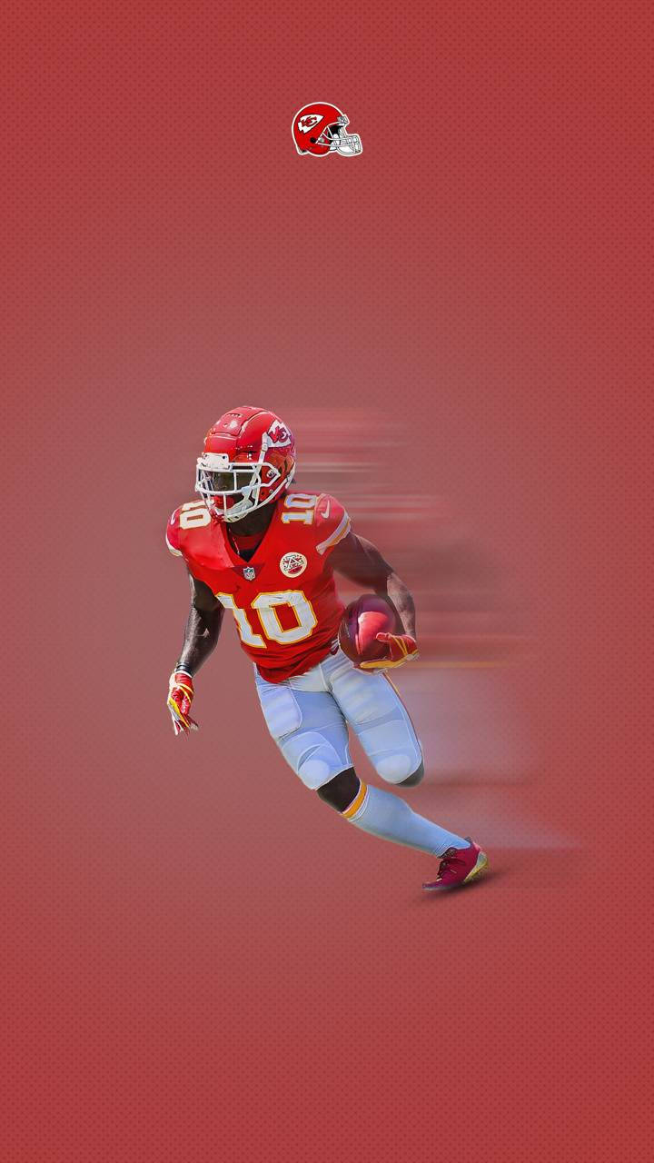 Tyreek Hill 桌布 壁紙 — 一名堪薩斯城酋長隊的足球員身穿紅色10號球衣，在紋理紅色背景上持球衝刺。