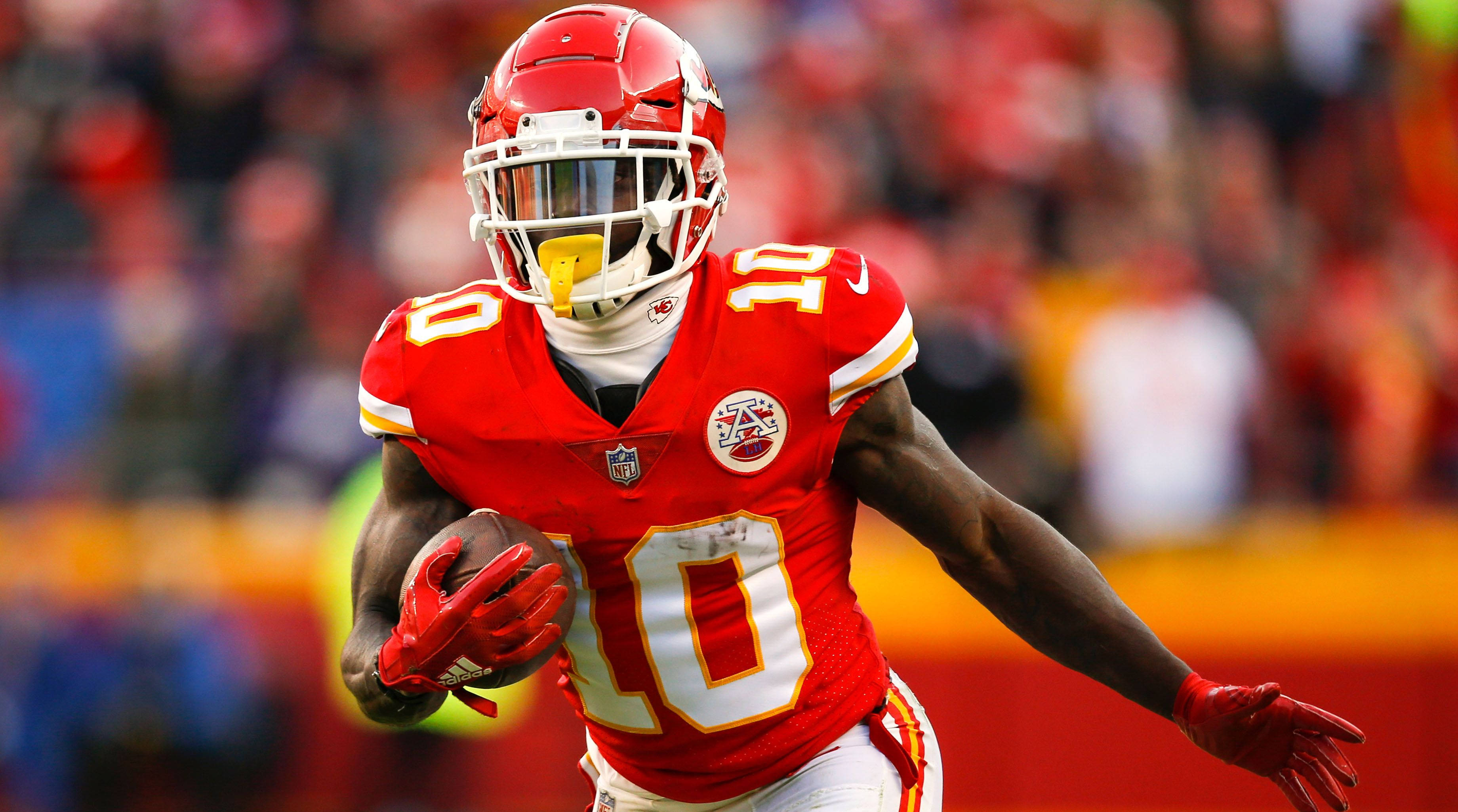 Tyreek Hill 桌布 壁紙 — 一名堪薩斯城酋長隊的足球運動員身穿紅色10號球衣，在比賽中帶球衝刺。
