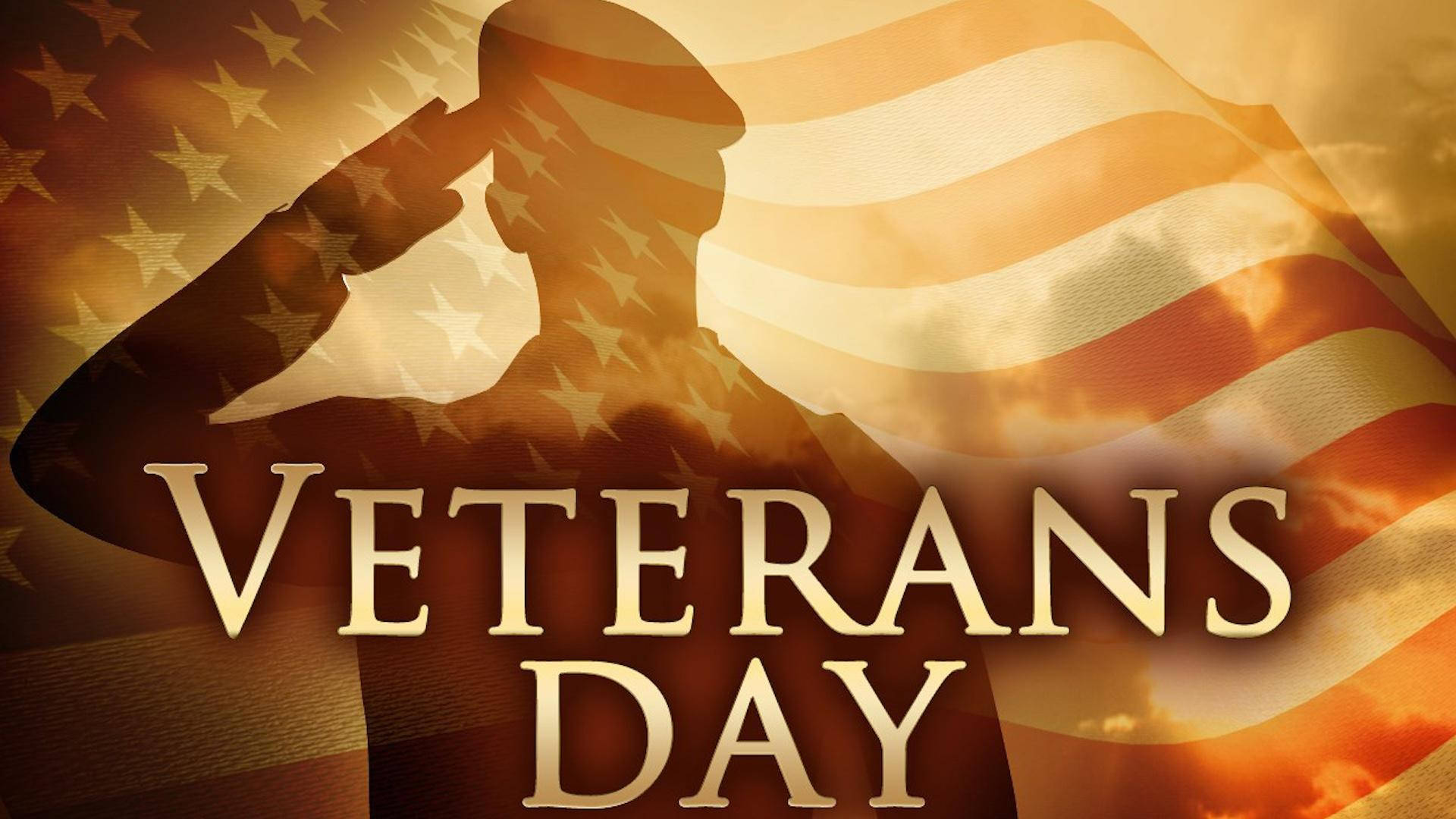 Veterans 桌布 壁紙 — 一名士兵在日落時分向飄揚的美國國旗敬禮的剪影，並帶有粗體的退伍軍人節文字。