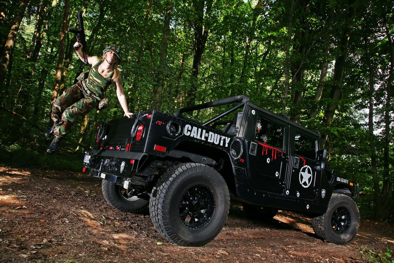 Call Of Duty Vehicles 桌布 壁紙 — 一名士兵在茂密的綠色森林中從一輛黑色 Call of Duty 品牌的 Humvee 跳下。