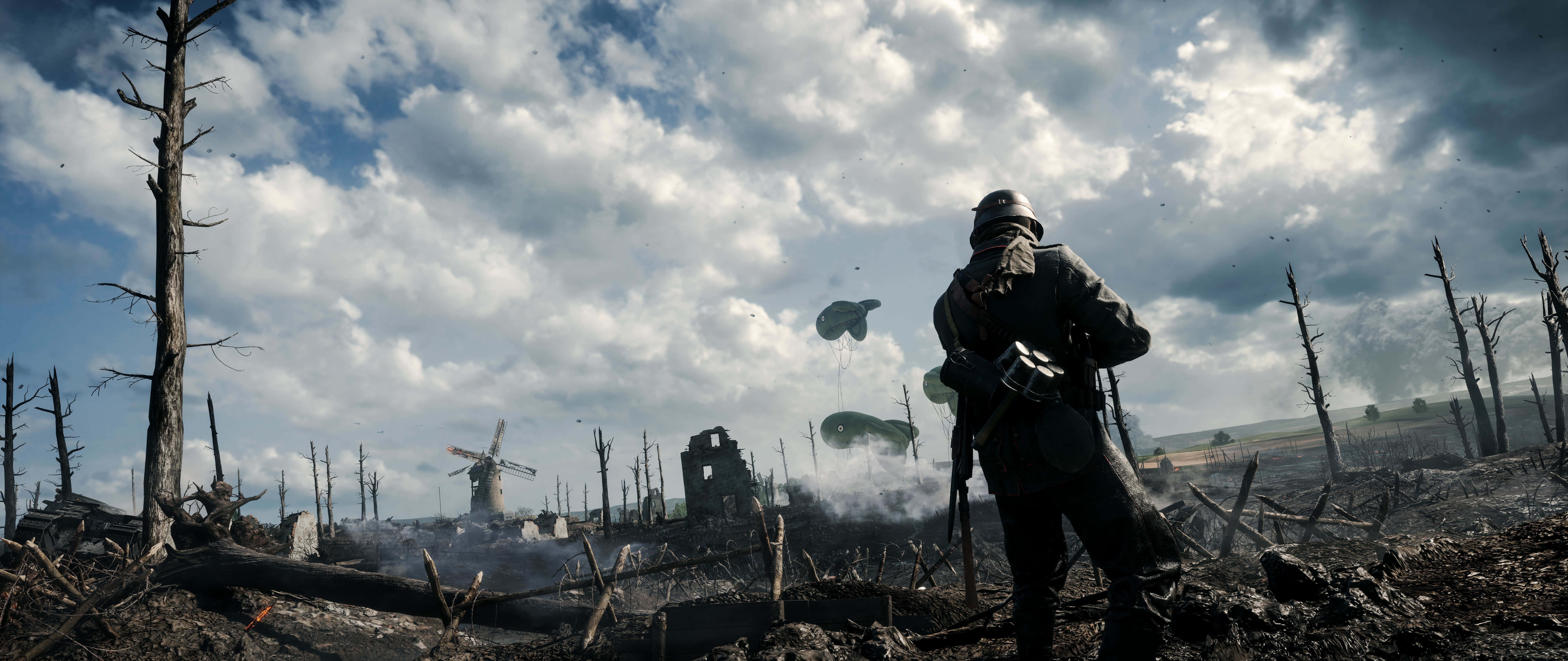 4K Battlefield 桌布 壁紙 — 一名士兵站在荒涼的戰區，周圍是斷樹和廢墟建築，天空多雲。