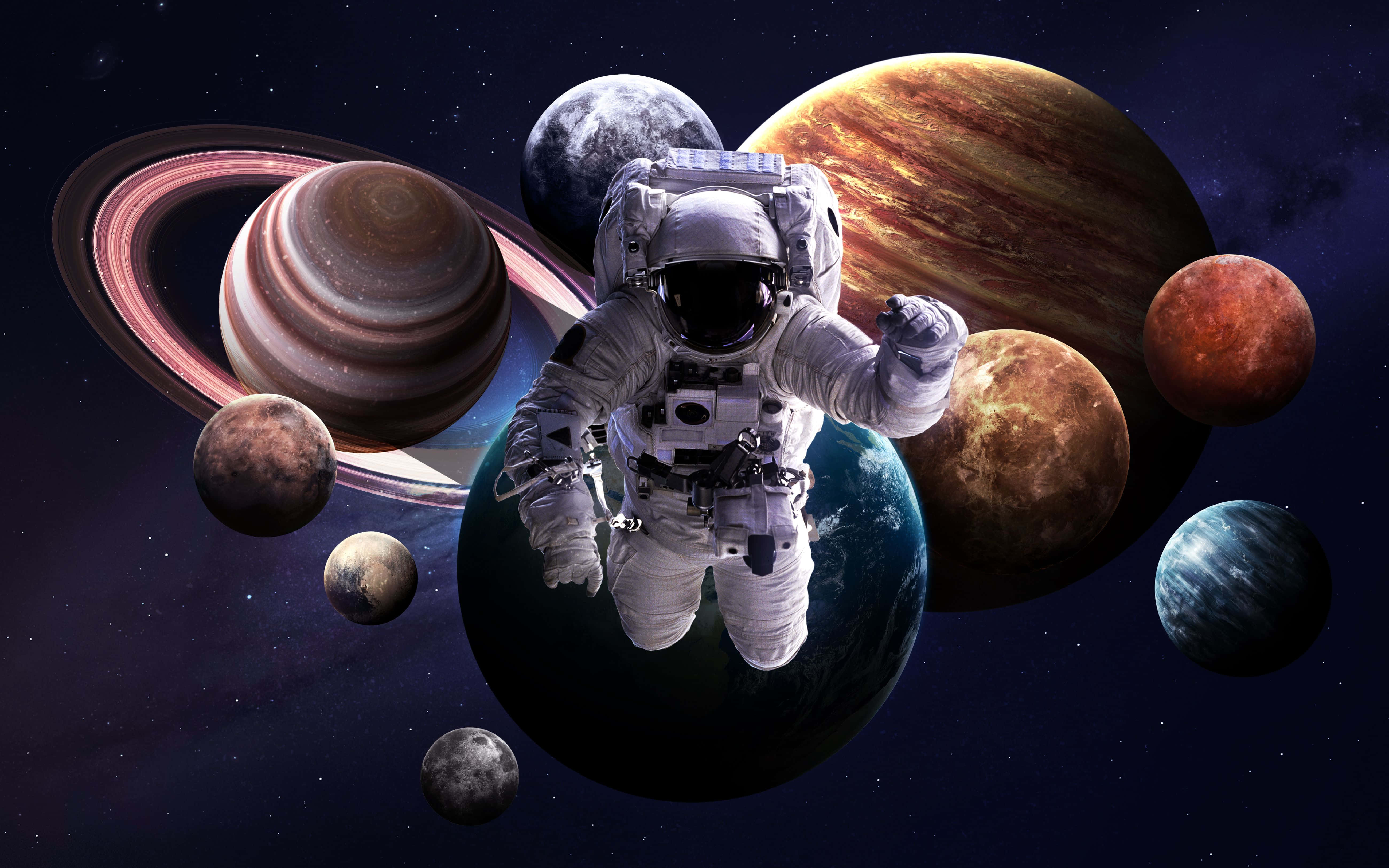 外太空 桌布 壁紙 — 一名太空人在充滿活力的宇宙場景中漂浮，周圍是色彩繽紛的行星和環，背景是繁星點點的虛空。