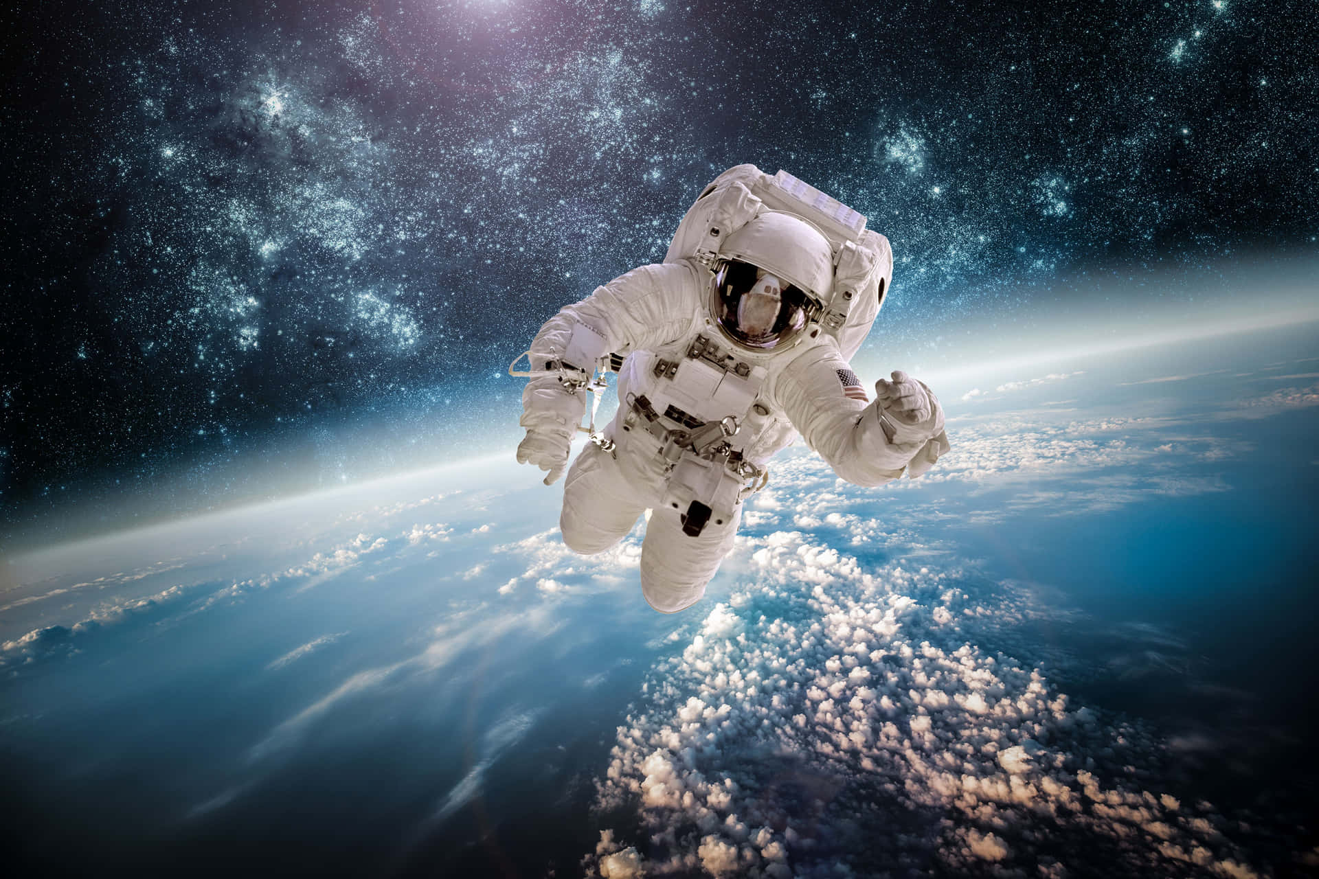  壁紙 — 一名太空人在地球藍色雲層覆蓋的表面上方失重漂浮，背景是星光燦爛的宇宙。