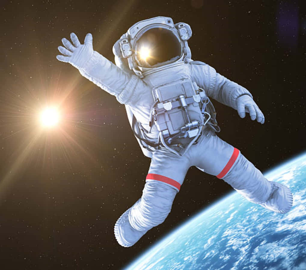  壁紙 — 一名太空人在太空中張開雙臂漂浮，背景是地球和耀眼的太陽。