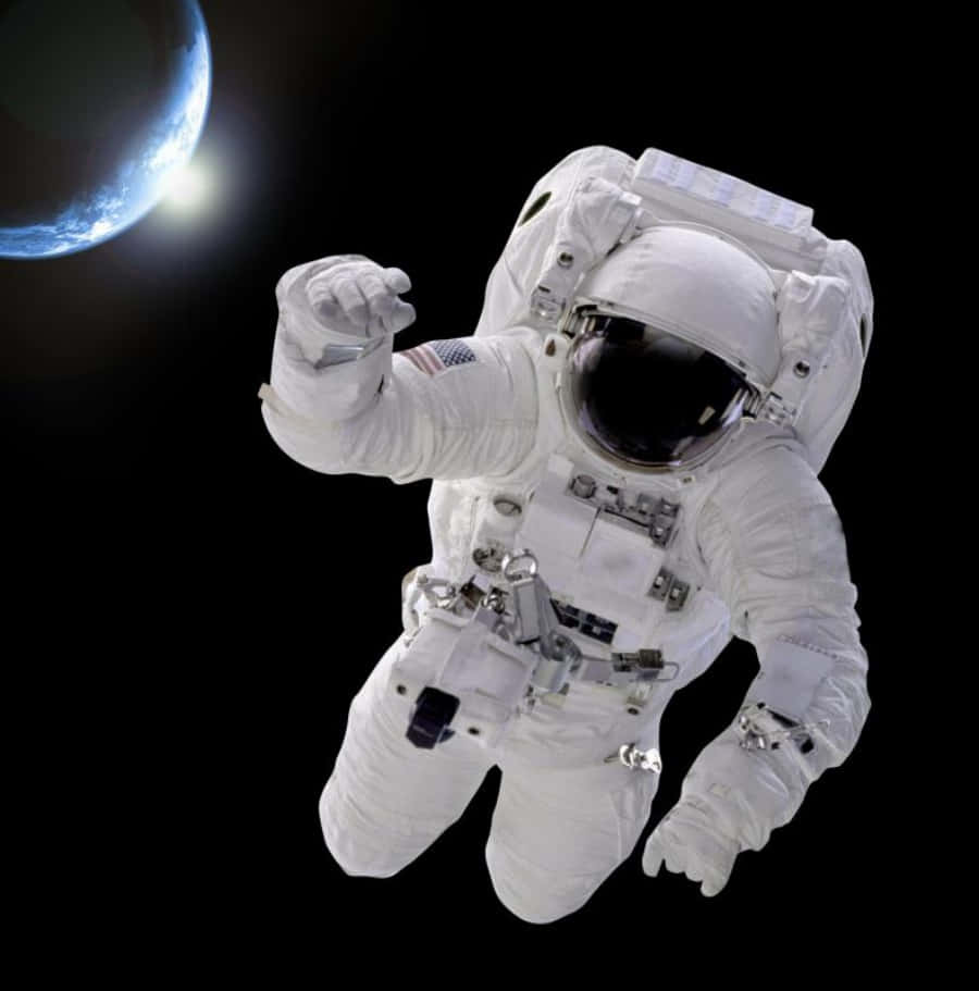 太空人 桌布 壁紙 — 一名太空人在太空漂浮，背景是發出藍光的地球，襯托著無星的虛空。