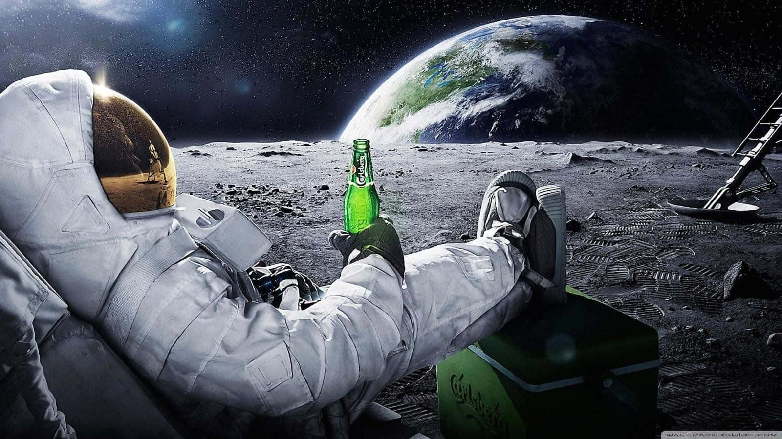  壁紙 — 一名太空人在月球表面放鬆，手持綠色啤酒瓶，背景中地球升起。