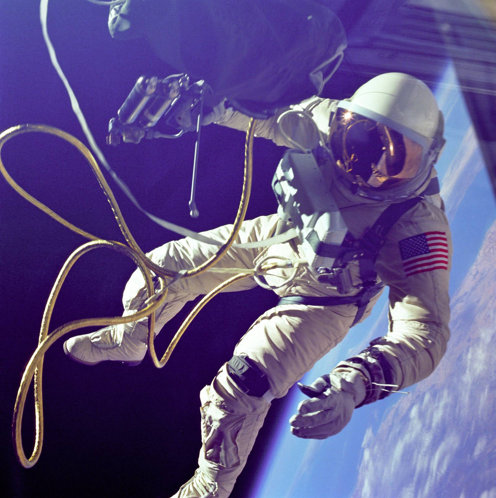 Astronaut In Space 桌布 壁紙 — 一名太空人在零重力下漂浮在太空船外，下方可見地球的藍色曲線。