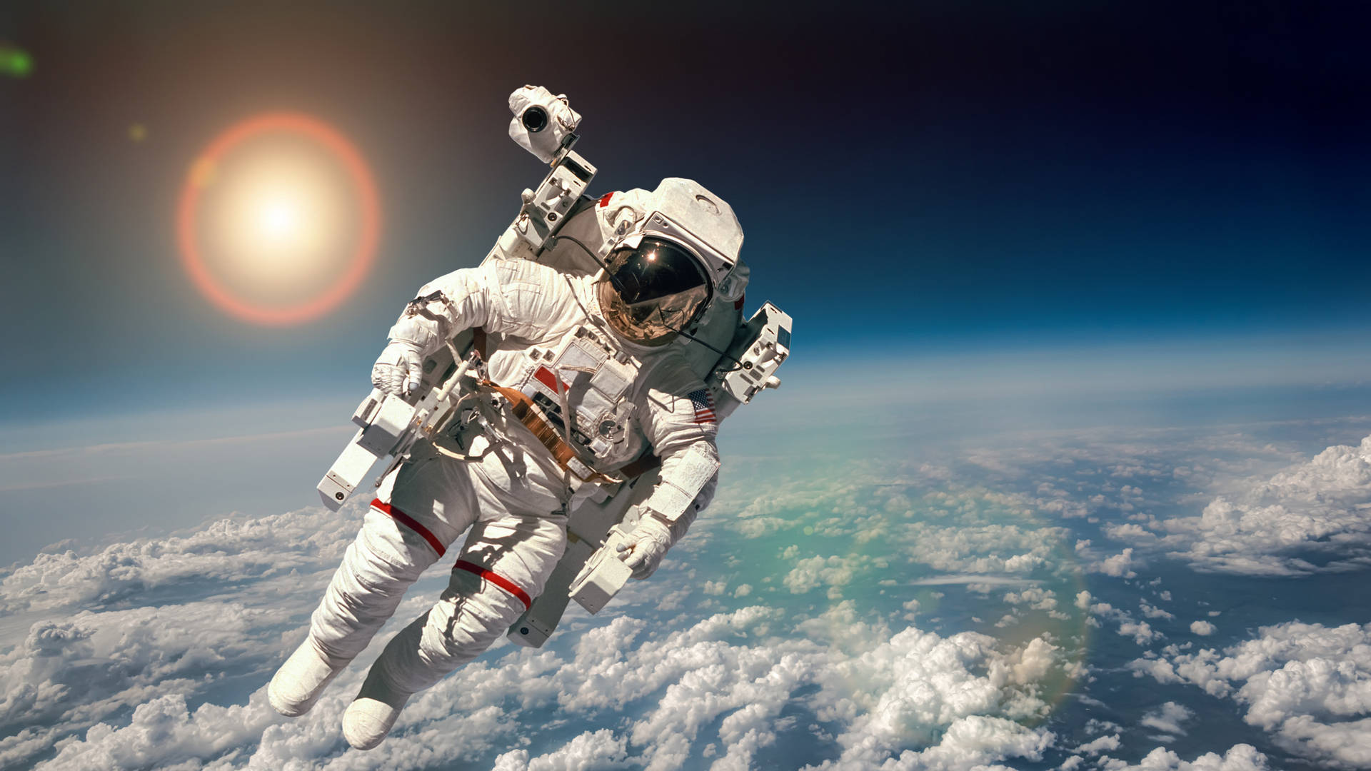  壁紙 — 一名太空人無重漂浮在地球雲層之上，背景太陽猛烈燃燒。
