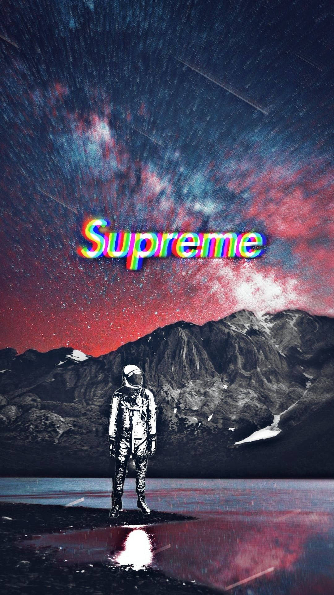 Cool Supreme 桌布 壁紙 — 一名太空人獨自站在反射湖面上，前方是積雪的山脈，下方是充滿活力的星空，而「Supreme」這個詞以故障彩虹文字發光。