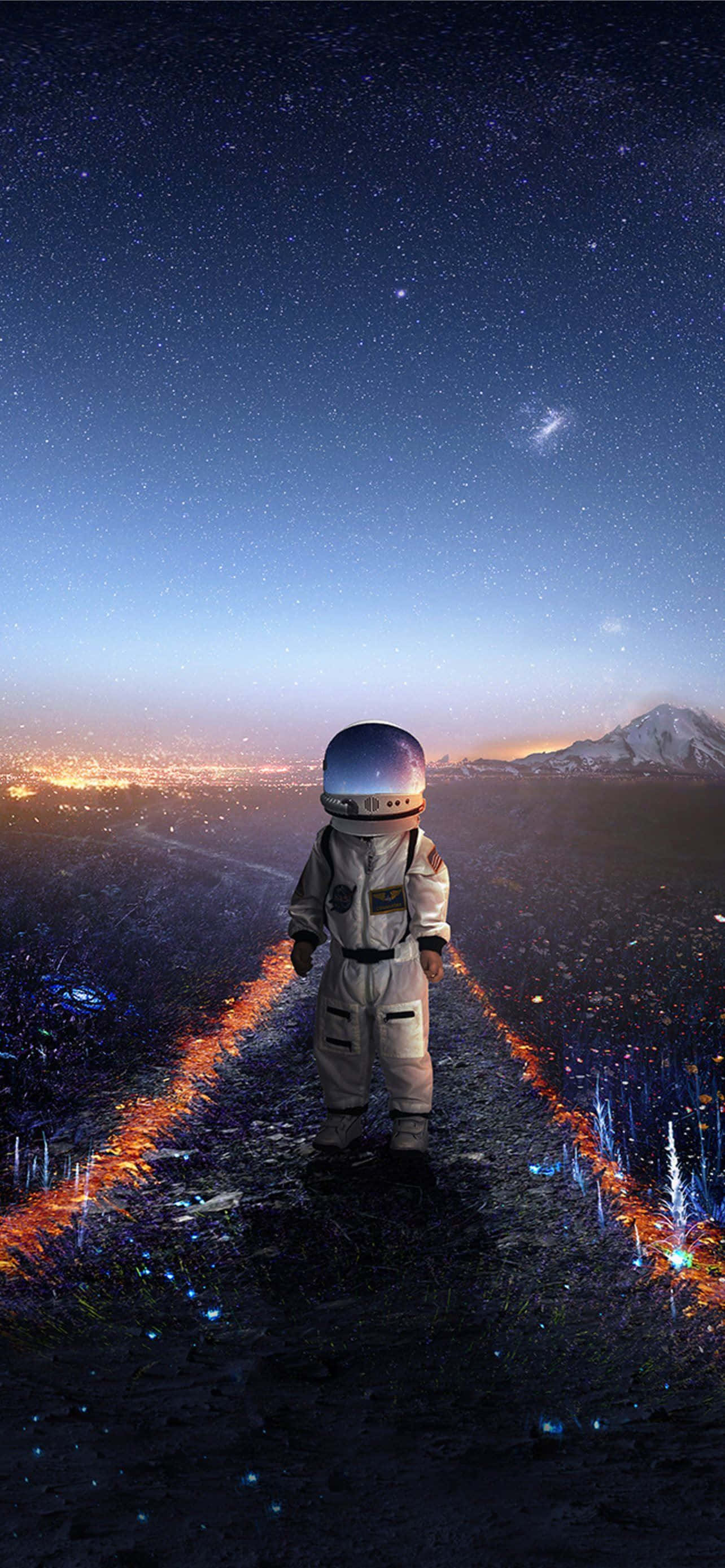 太空人 桌布 壁紙 — 一名太空人獨自站在發光的小徑上，在星空下俯瞰遠方的城市和雪山。