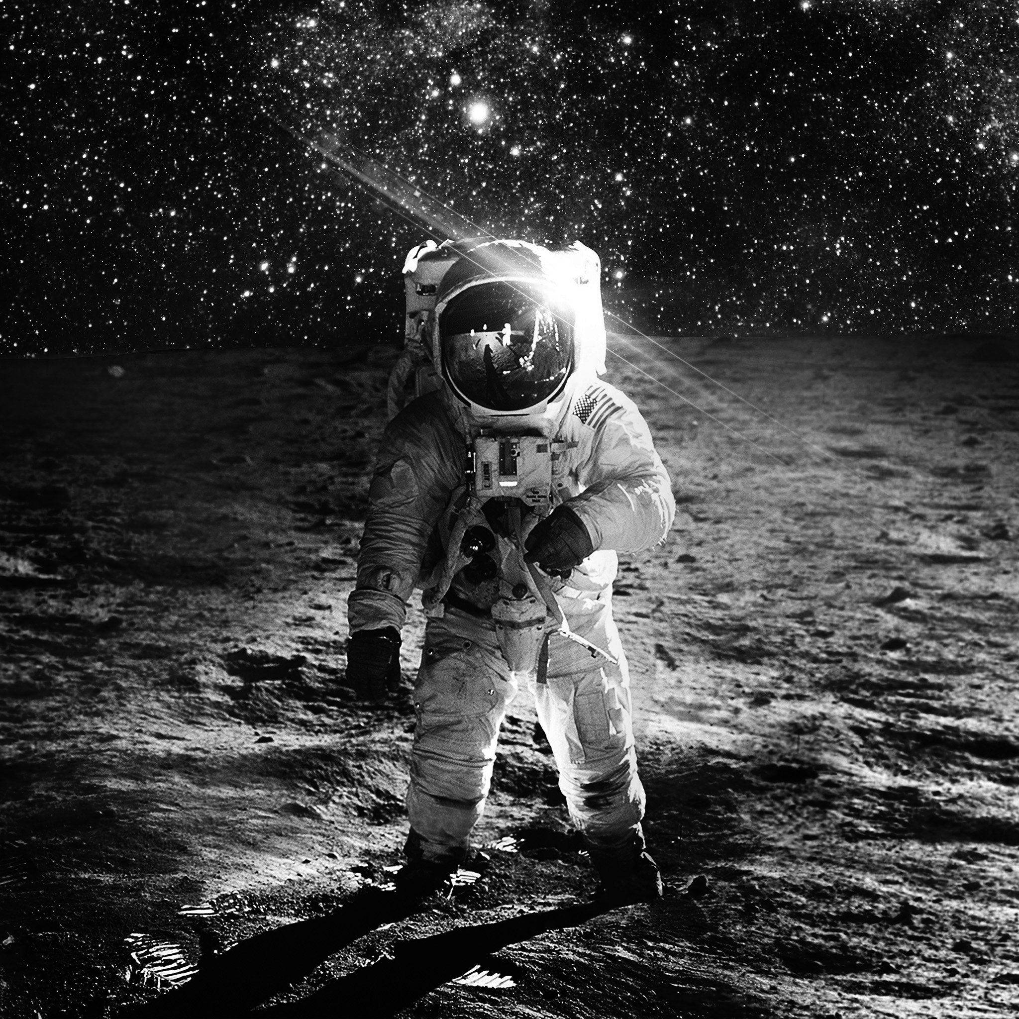 太空人 桌布 壁紙 — 一名太空人站在月球表面，星空下，遠處可見地球。
