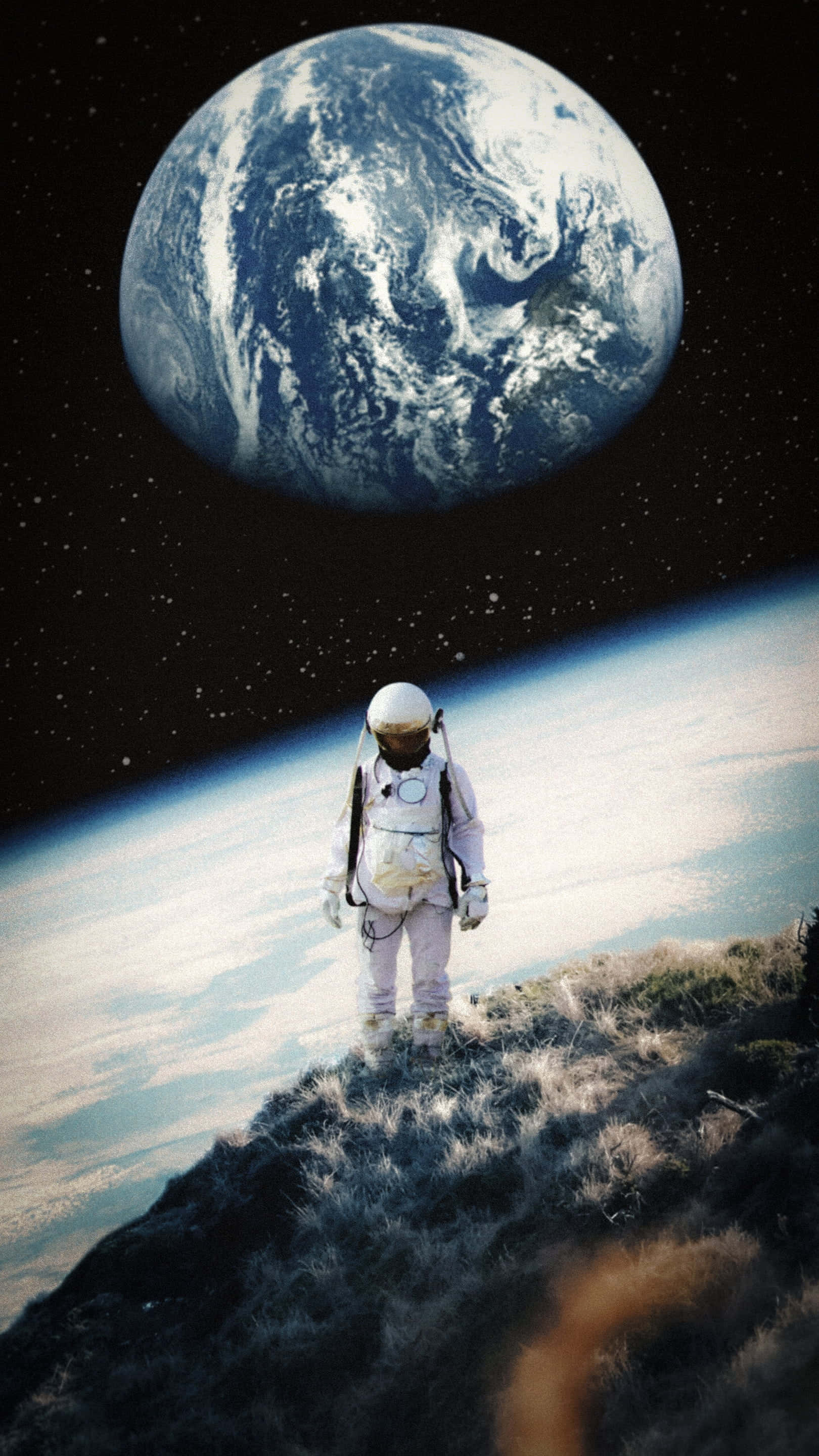 Alone 桌布 壁紙 — 一名太空人站在長滿草的山頂上，凝視著地球在太空彎曲的地平線上升起。
