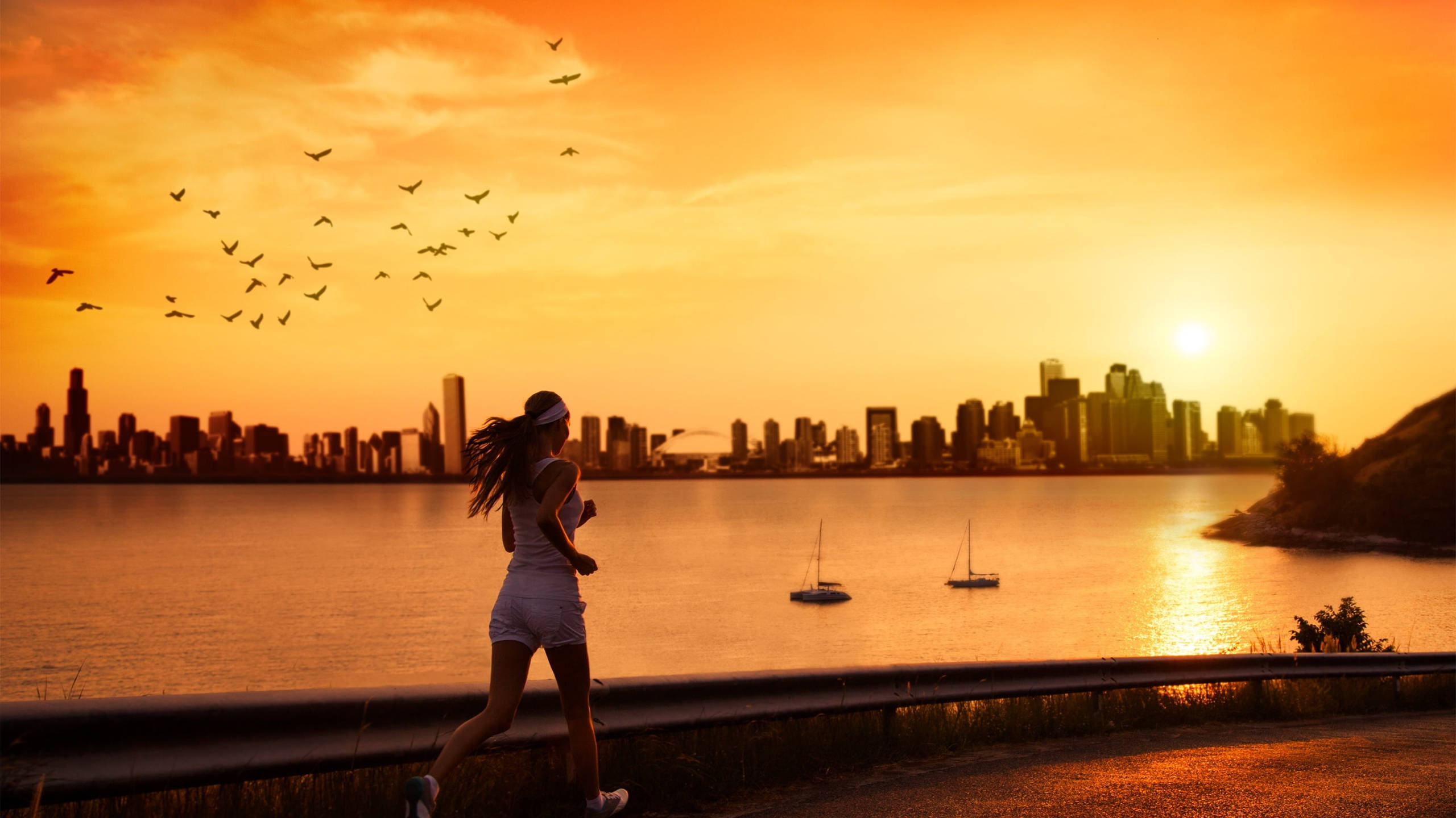 Running 桌布 壁紙 — 一名女子在日落時沿著海濱小徑跑步，背景是城市天際線和帆船。