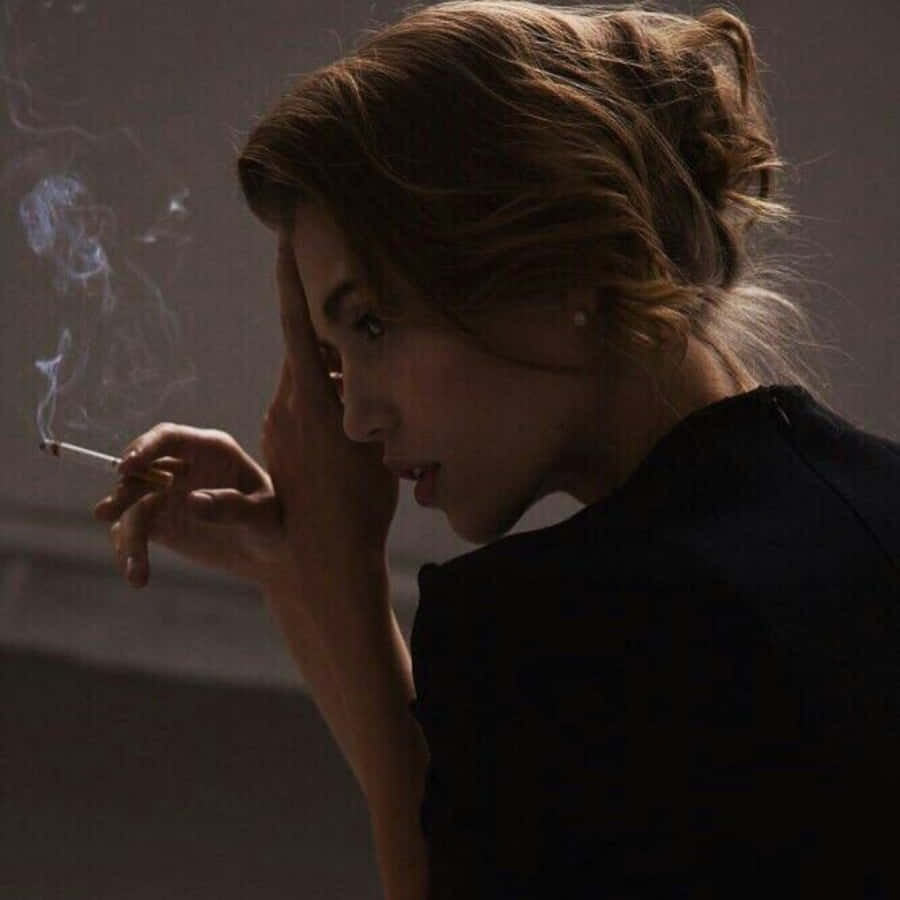 一名女子在昏暗的房間裡抽菸 壁紙