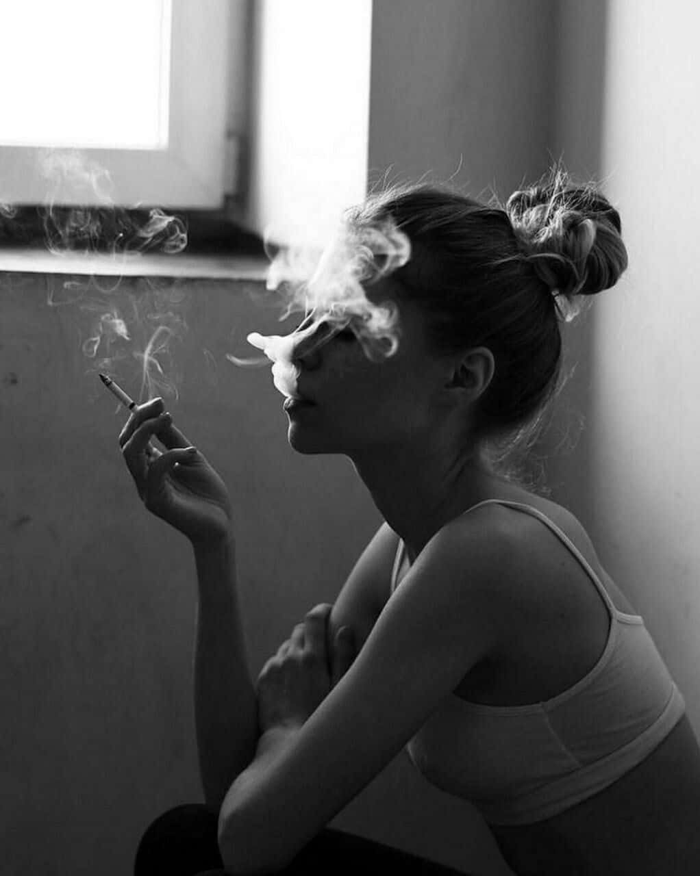 一名女子在窗前抽煙 壁紙