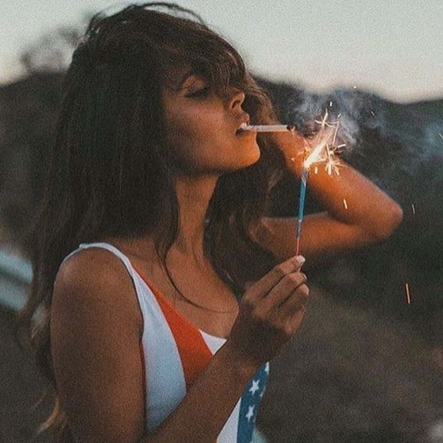 一名女子站在山坡上手持仙女棒 壁紙