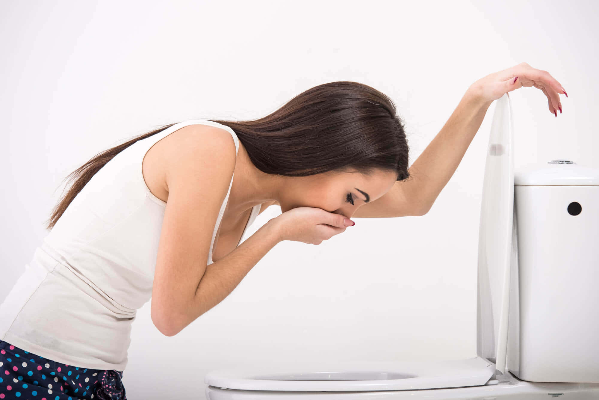 Vomit 桌布 壁紙 — 一名女性在純白背景前，痛苦地用手掩住嘴巴，俯身靠近馬桶。