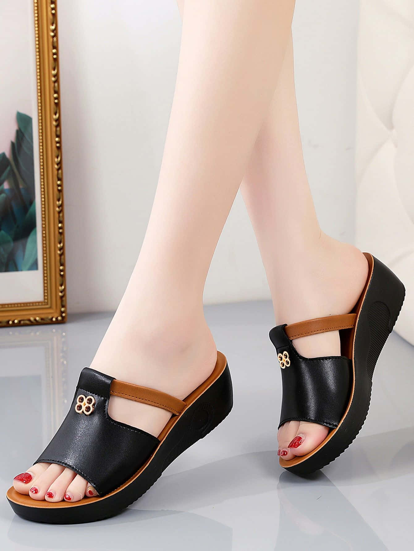 Sandals 桌布 壁紙 — 一名女性穿著帶有金色花卉裝飾的黑色厚底涼鞋，腳趾甲塗成紅色，站在光澤地板上，旁邊有一幅裱框照片。