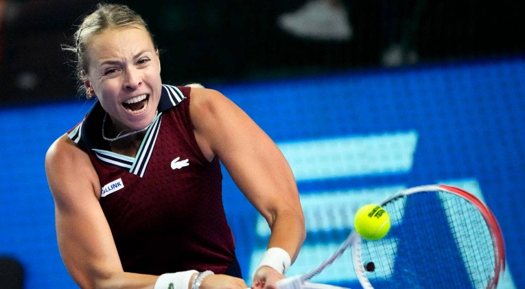 Athletic 桌布 壁紙 — 一名女網球運動員在藍色球場背景下，用球拍猛擊黃色球，並發出尖叫，神情專注。