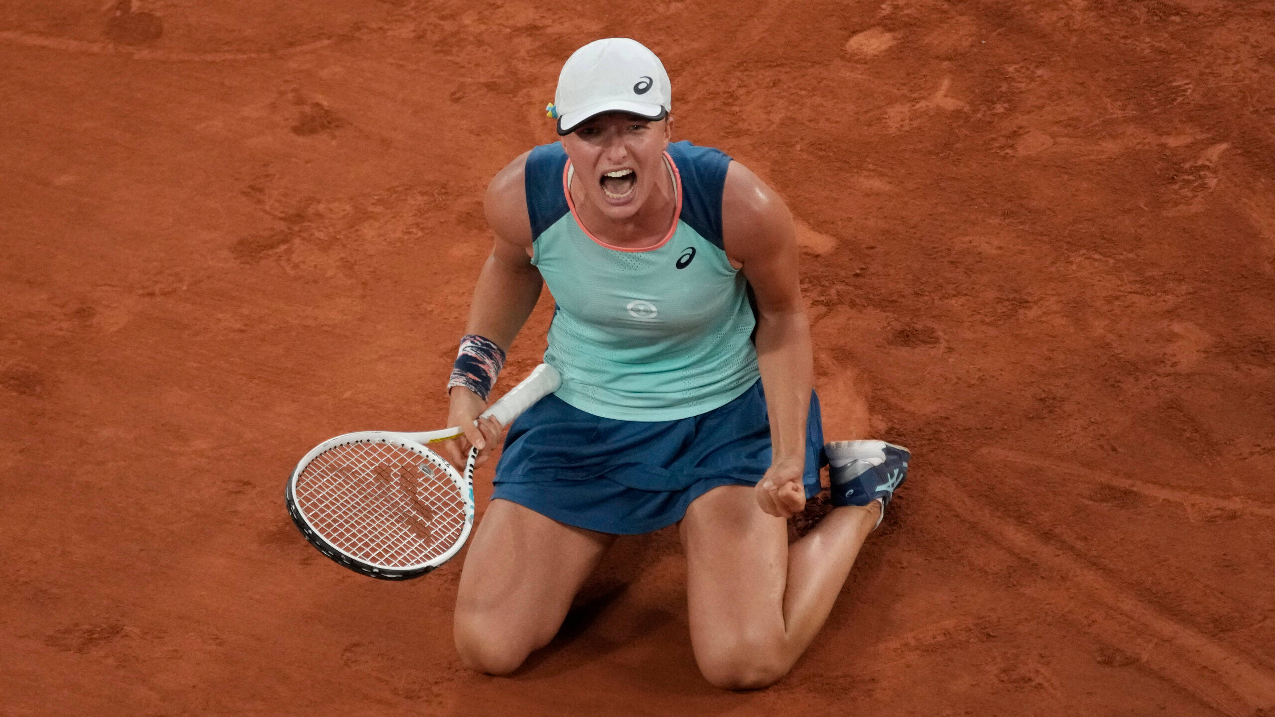 Athlete 桌布 壁紙 — 一名女網球選手跪在紅土球場上，握緊球拍，勝利地尖叫。