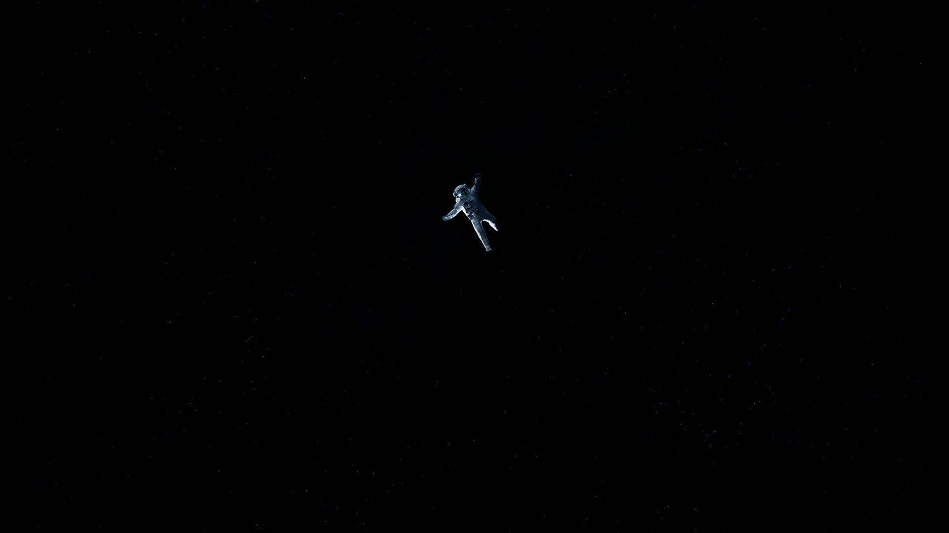 Black And White Astronaut 桌布 壁紙 — 一名孤獨的太空人在浩瀚星空的背景下，在寂靜的太空中無重力漂浮。