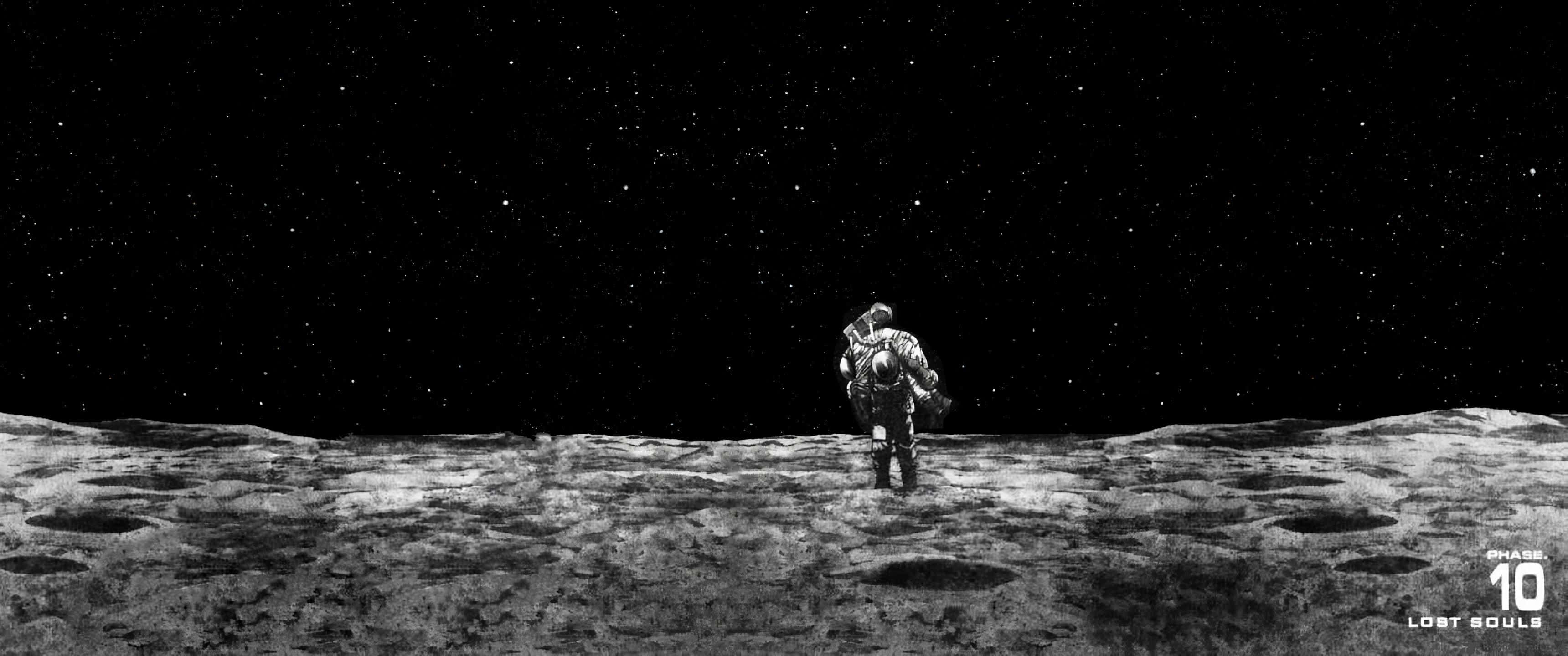 Ultra Wide 3440x1440 Space 桌布 壁紙 — 一名孤獨的太空人站在佈滿隕石坑的月球表面，上方是佈滿星星的黑色天空。