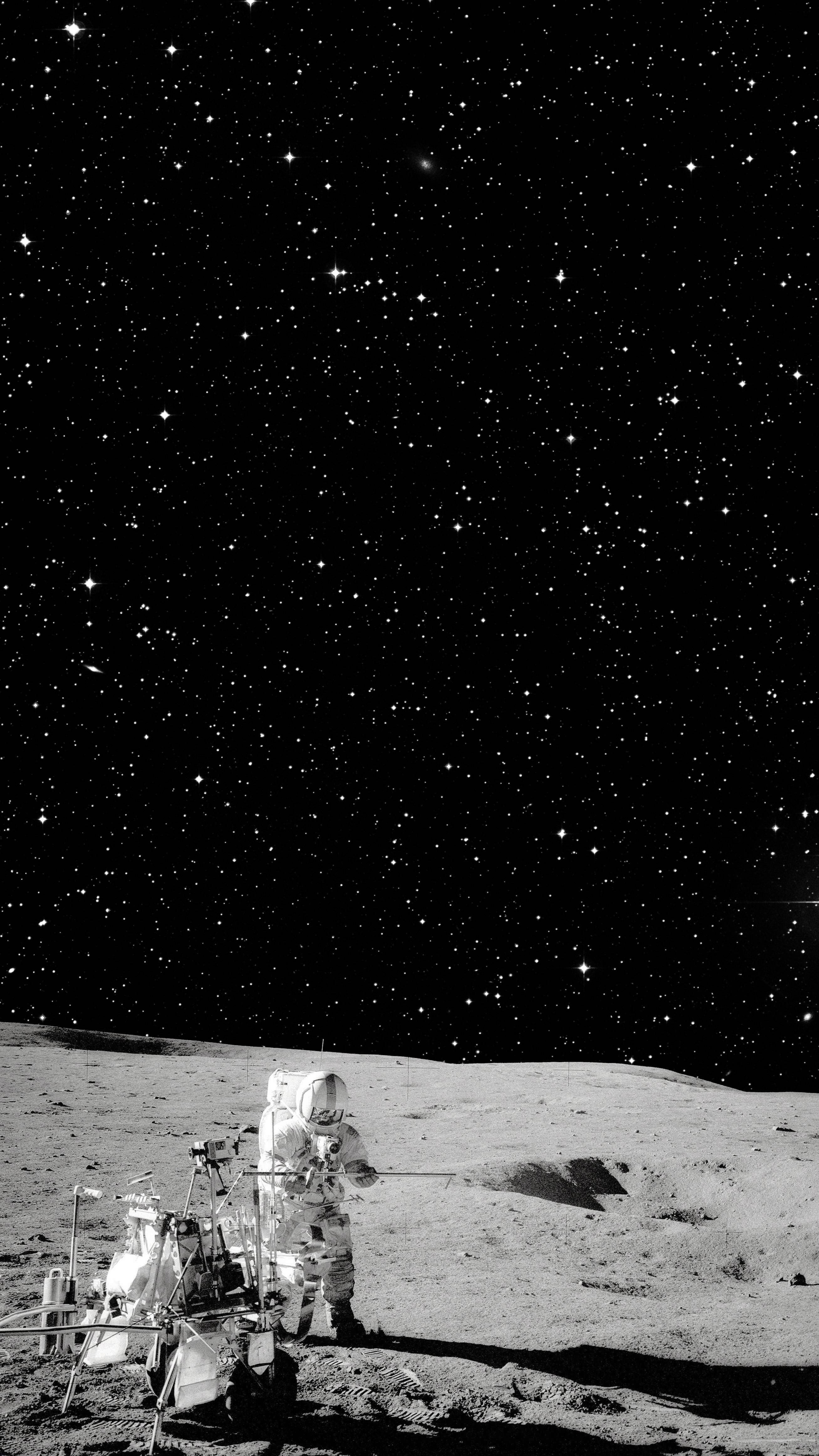 Astronaut In Space 桌布 壁紙 — 一名孤獨的太空人站在月球荒蕪的表面，下方是佈滿星星的黑色天空，附近有一輛月球車。
