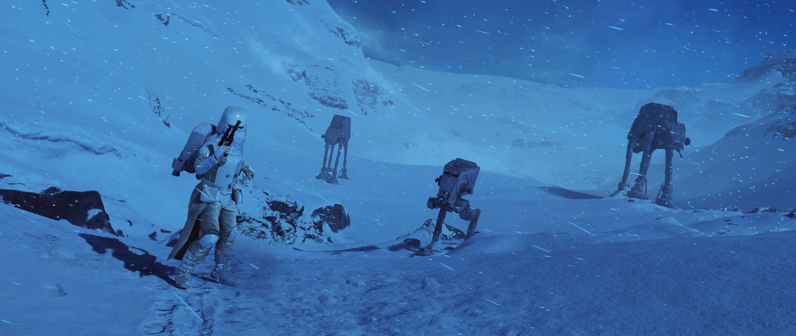 星際大戰 桌布 壁紙 — 一名孤獨的雪地士兵在冰封星球上穿越暴風雪前進，AT-AT 步行機在星空下遠處若隱若現。
