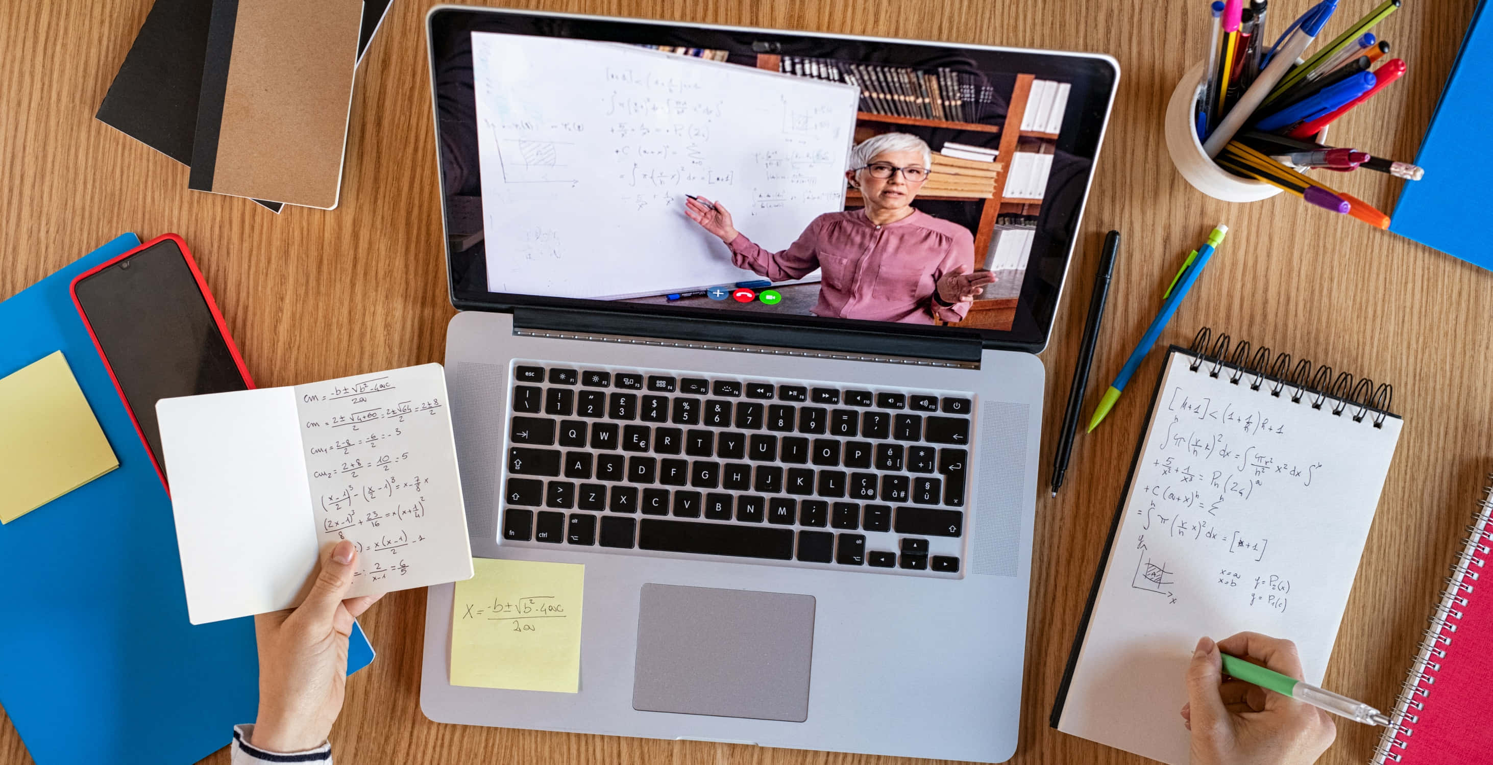 Education 桌布 壁紙 — 一名學生在線上數學課中，教授在白板上寫方程式時做筆記。