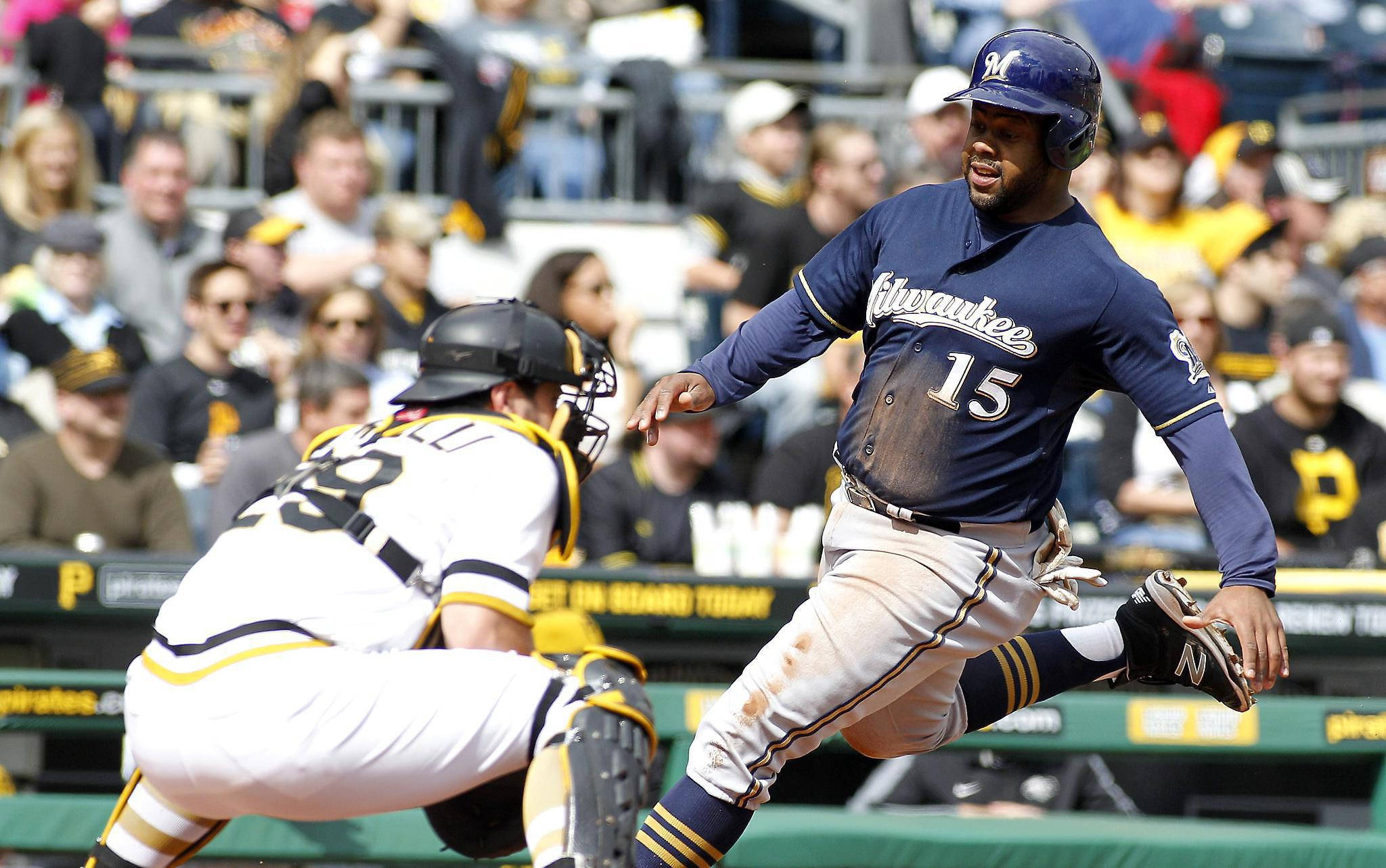 Brewers 桌布 壁紙 — 一名密爾瓦基釀酒人棒球選手在日間比賽中衝刺越過捕手，背景有歡呼的球迷。