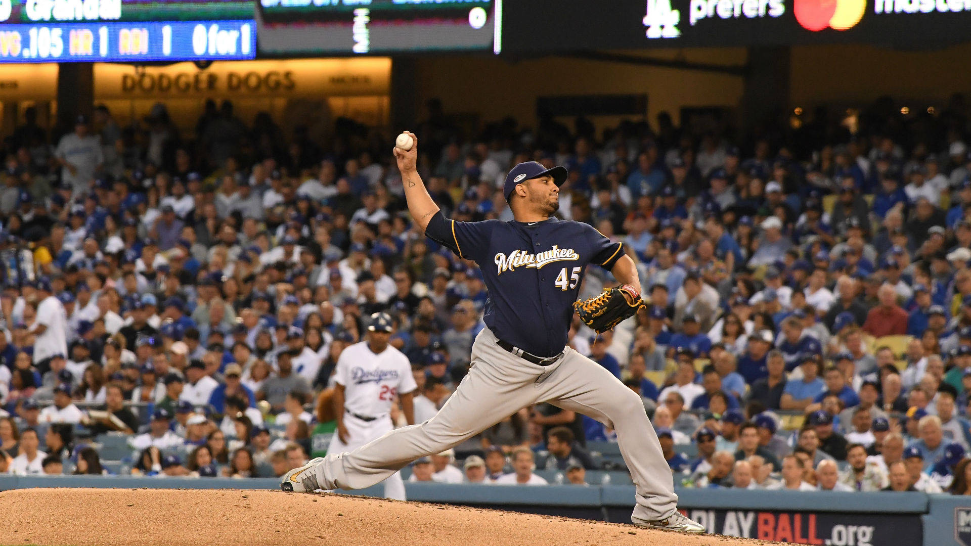 Brewers 桌布 壁紙 — 一名密爾瓦基釀酒人隊的投手在投手丘上投球，身後是擠滿觀眾的球場，在明亮的球場燈光下。