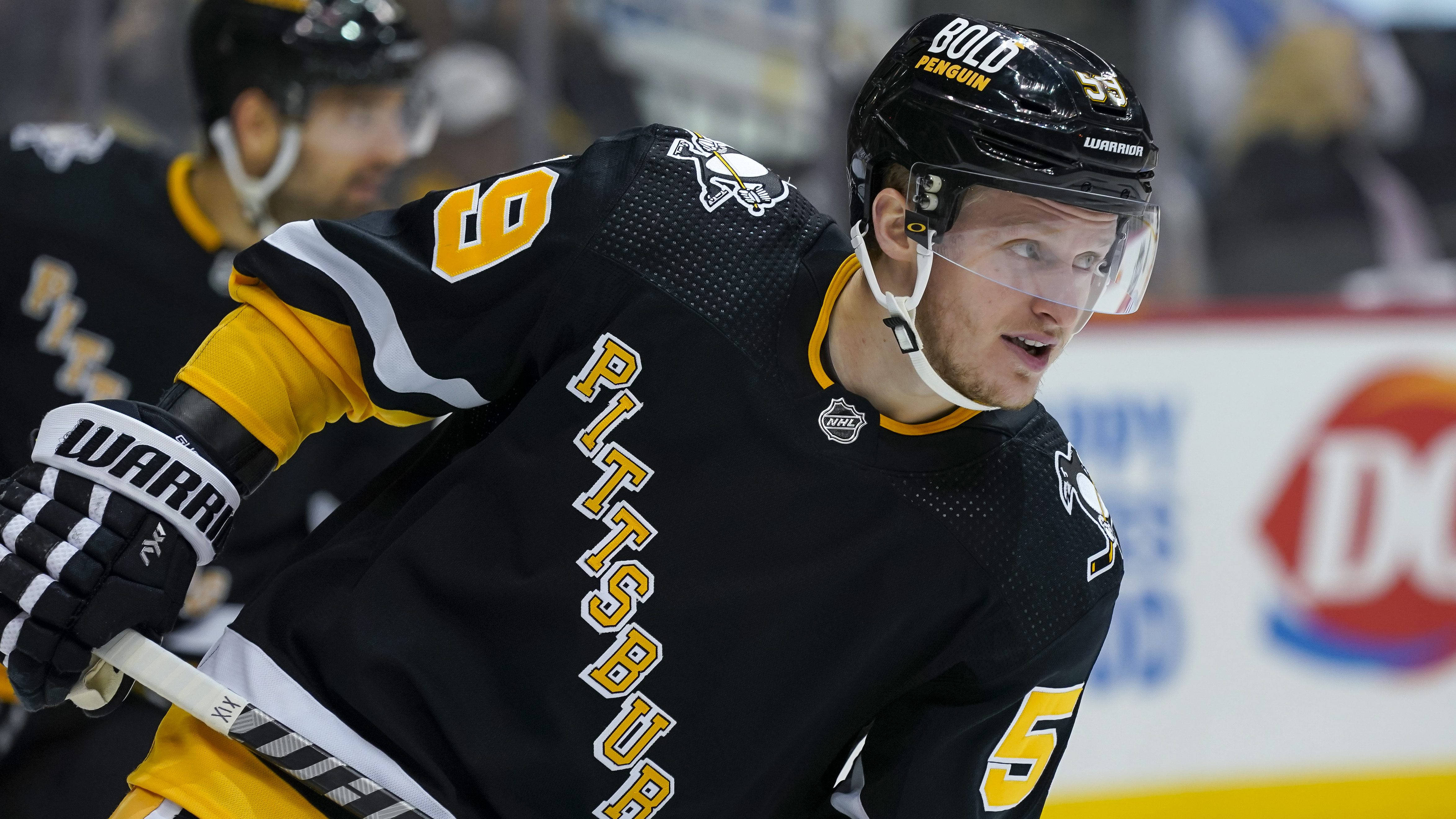 hockey 桌布 壁紙 — 一名專注的匹茲堡企鵝冰球球員，身穿黑色和金色裝備，在比賽期間於冰上向前傾身。