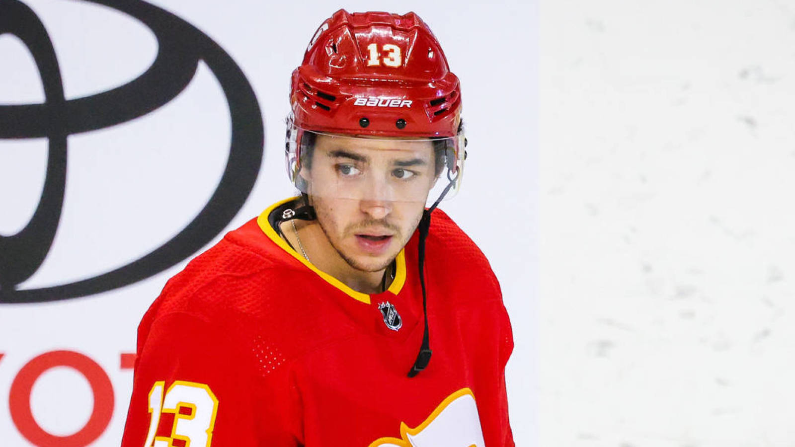 Johnny Gaudreau 桌布 壁紙 — 一名專注的曲棍球運動員身穿紅色球衣和頭盔，號碼13，在比賽中專注地凝視。