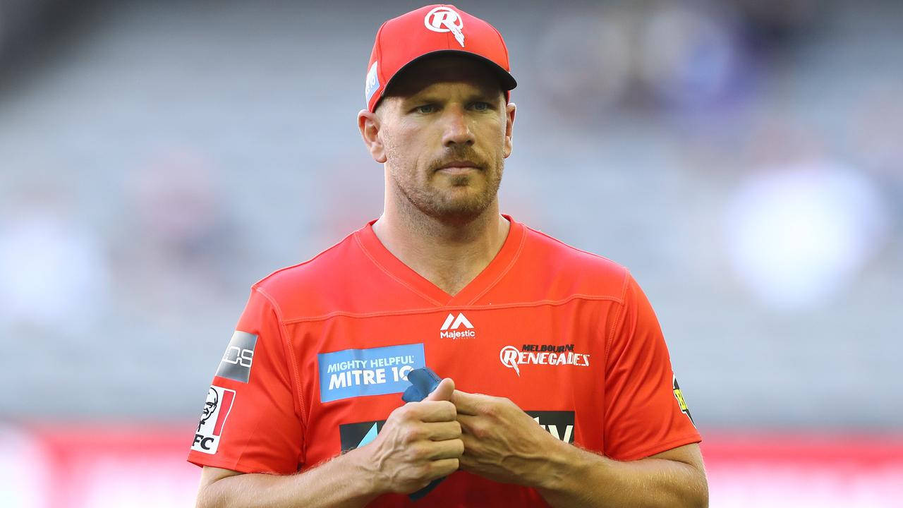 Aaron Finch 桌布 壁紙 — 一名專注的橄欖球聯賽球員，身穿紅色球衣和帽子，在模糊的體育場背景下拿著一個藍色水壺。