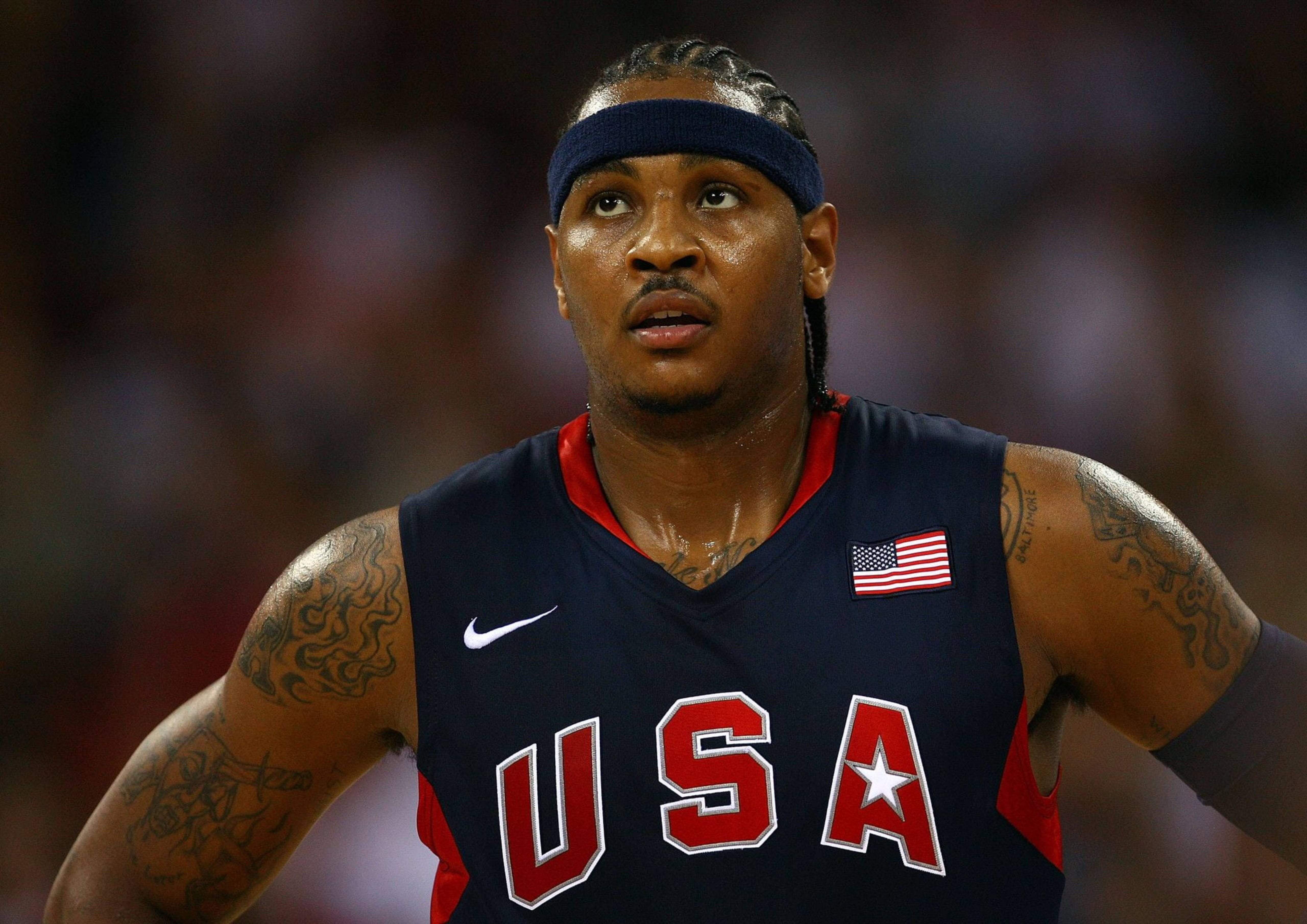 Carmelo 桌布 壁紙 — 一名專注的籃球運動員，身穿美國球衣，有刺青和頭帶，在比賽中。