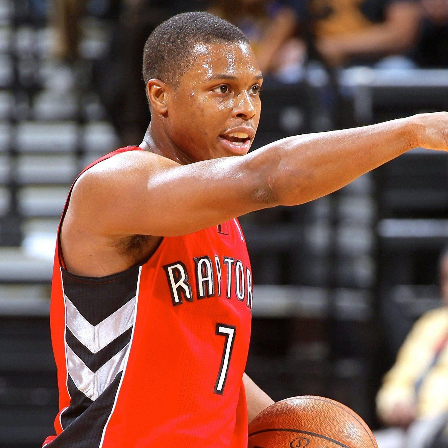 Lowry 桌布 壁紙 — 一名專注的籃球運動員穿著紅色Raptors球衣，在明亮的場館燈光下進行激烈比賽時運球並做手勢。