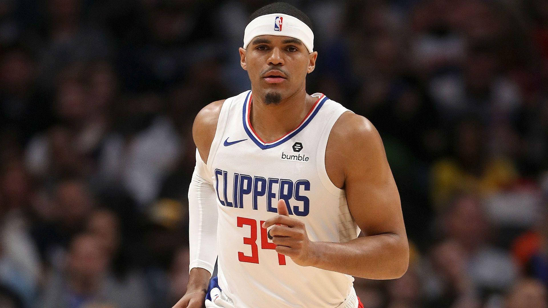NBA 桌布 壁紙 — 一名專注的籃球運動員身穿白色快艇隊球衣，號碼34，在明亮的場館燈光下比賽中奔跑。