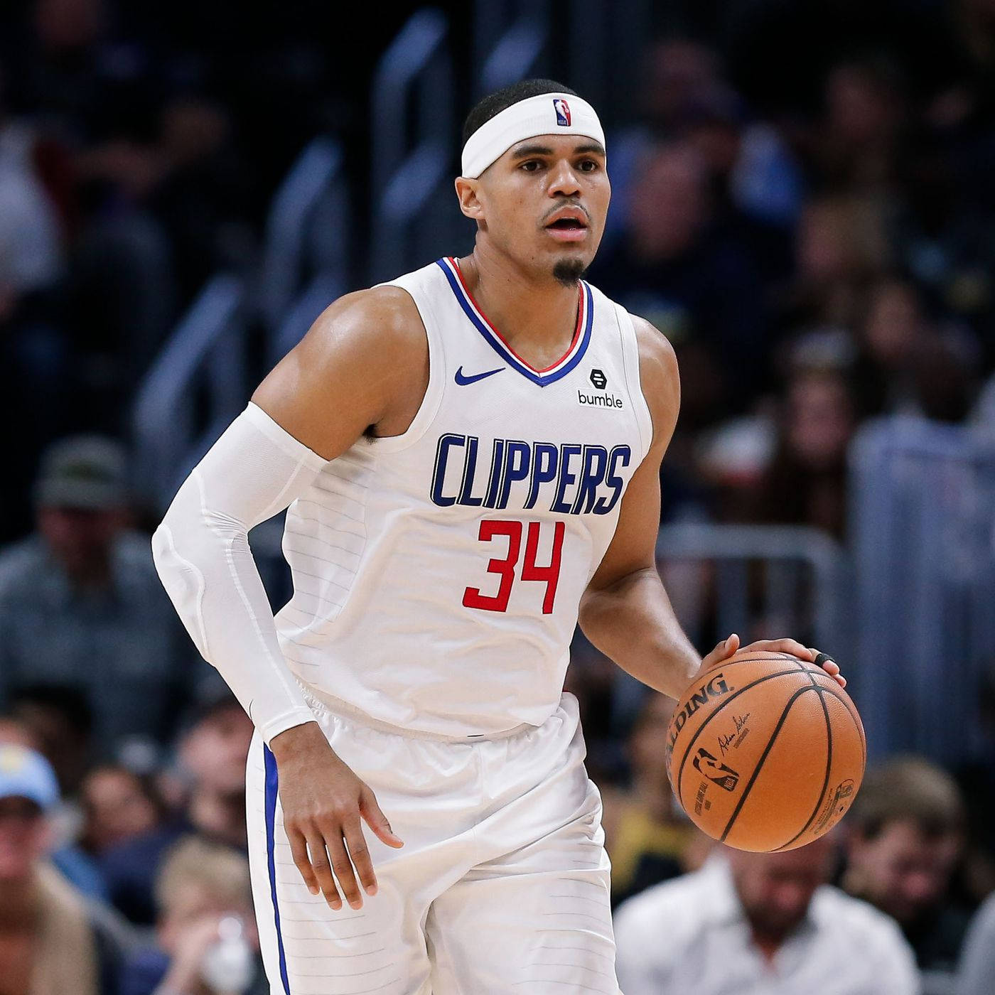 NBA 桌布 壁紙 — 一名專注的籃球運動員身穿白色快艇隊球衣，在明亮的場館燈光下於激烈的比賽中運球。
