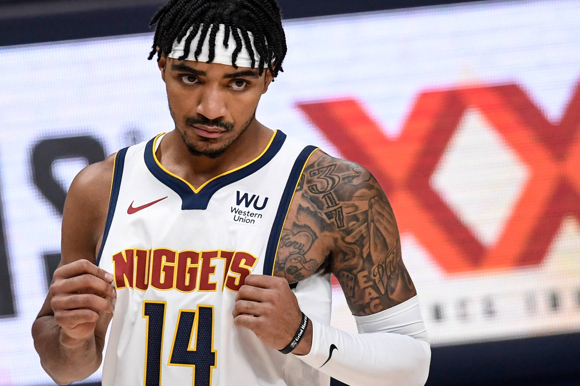 gary harris 桌布 壁紙 — 一名專注的籃球運動員身穿白色金塊隊球衣（14號），抓著球衣，紋身和頭帶清晰可見。