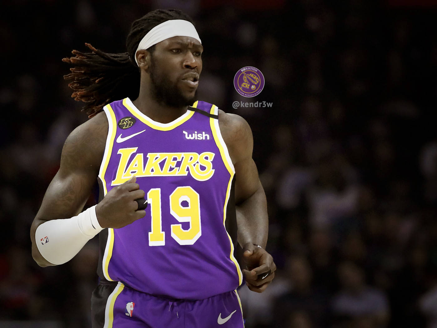montrezl harrell 桌布 壁紙 — 一名專注的籃球運動員身穿紫色湖人隊19號球衣，在場館燈光下於比賽中衝刺。