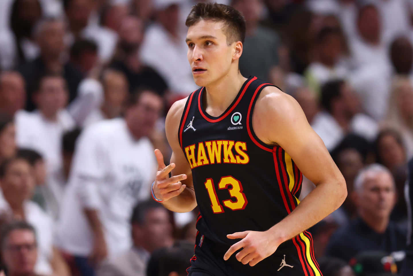 NBA 桌布 壁紙 — 一名專注的籃球運動員身穿黑色老鷹隊球衣，號碼13，在比賽中運球，背景是模糊的人群。