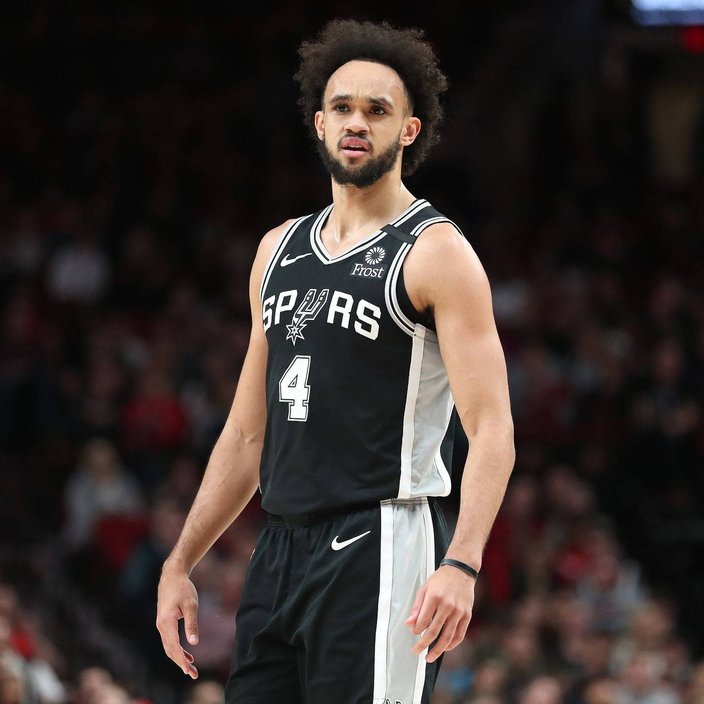 NBA 桌布 壁紙 — 一名專注的籃球運動員身穿黑色馬刺隊4號球衣，站在球場上，背景是模糊的觀眾。