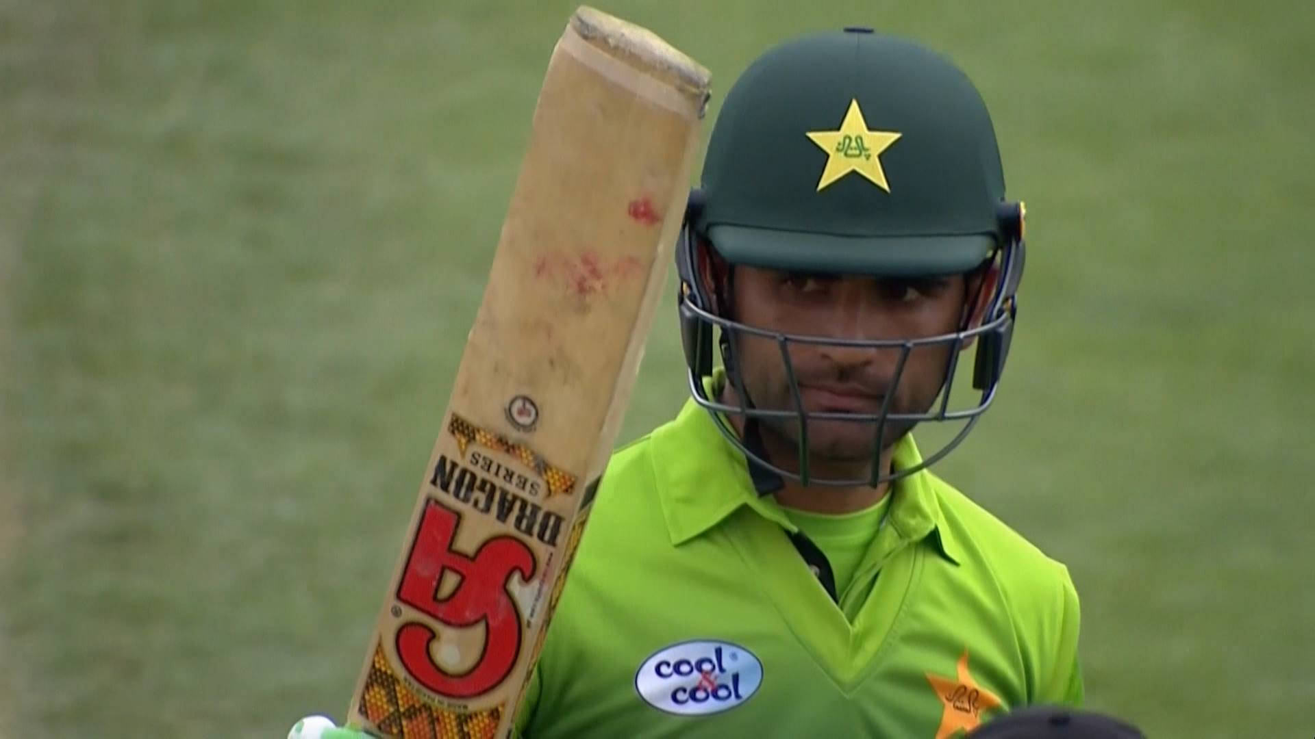 Fakhar Zaman 桌布 壁紙 — 一名巴基斯坦板球運動員身穿綠色制服，手持磨損的木製球棒，頭盔上有星形標誌。