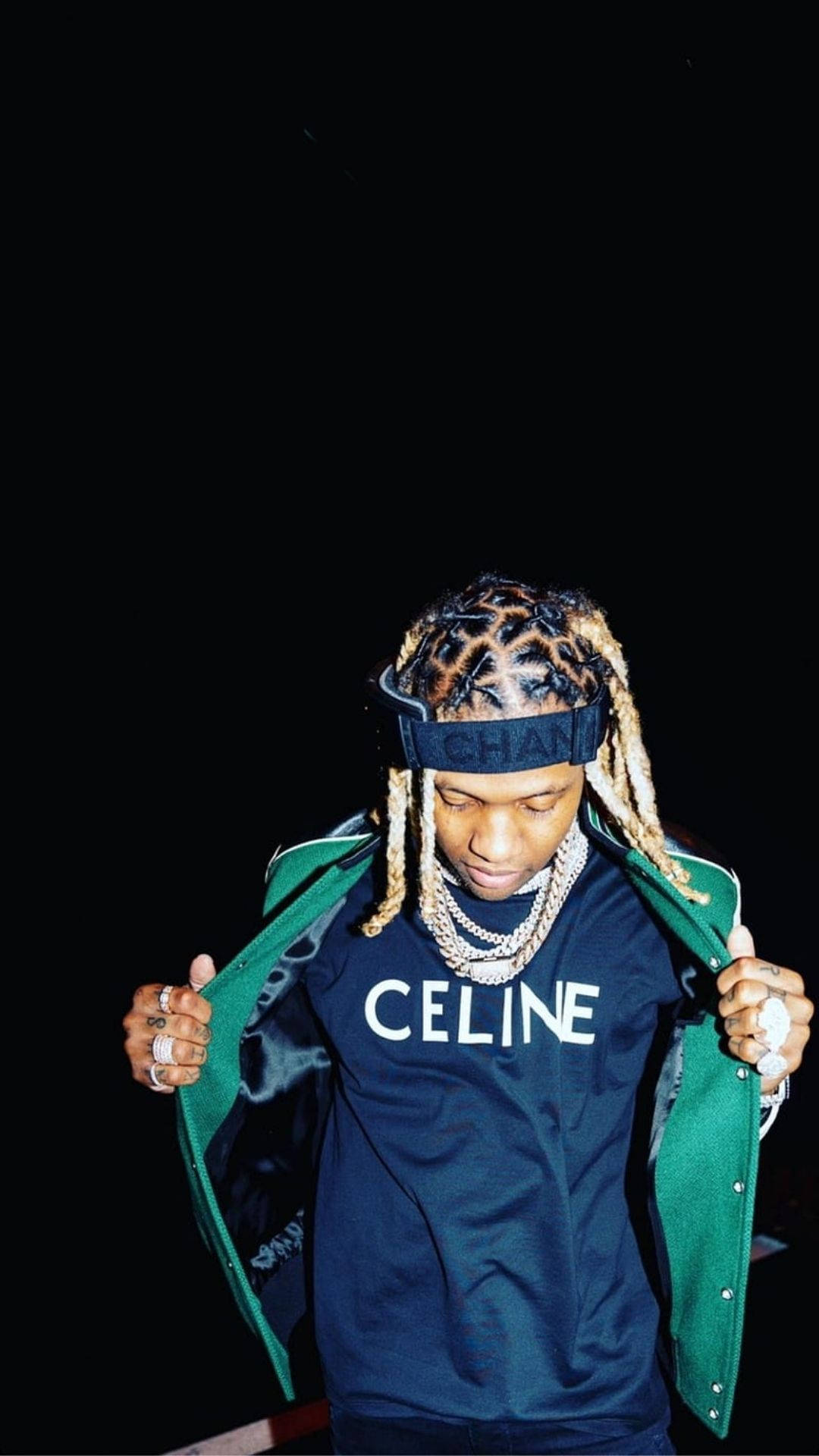 Lil Durk 桌布 壁紙 — 一名年輕男子梳著辮子，戴著 Chanel 頭帶，在黑色背景前拉開綠色外套。