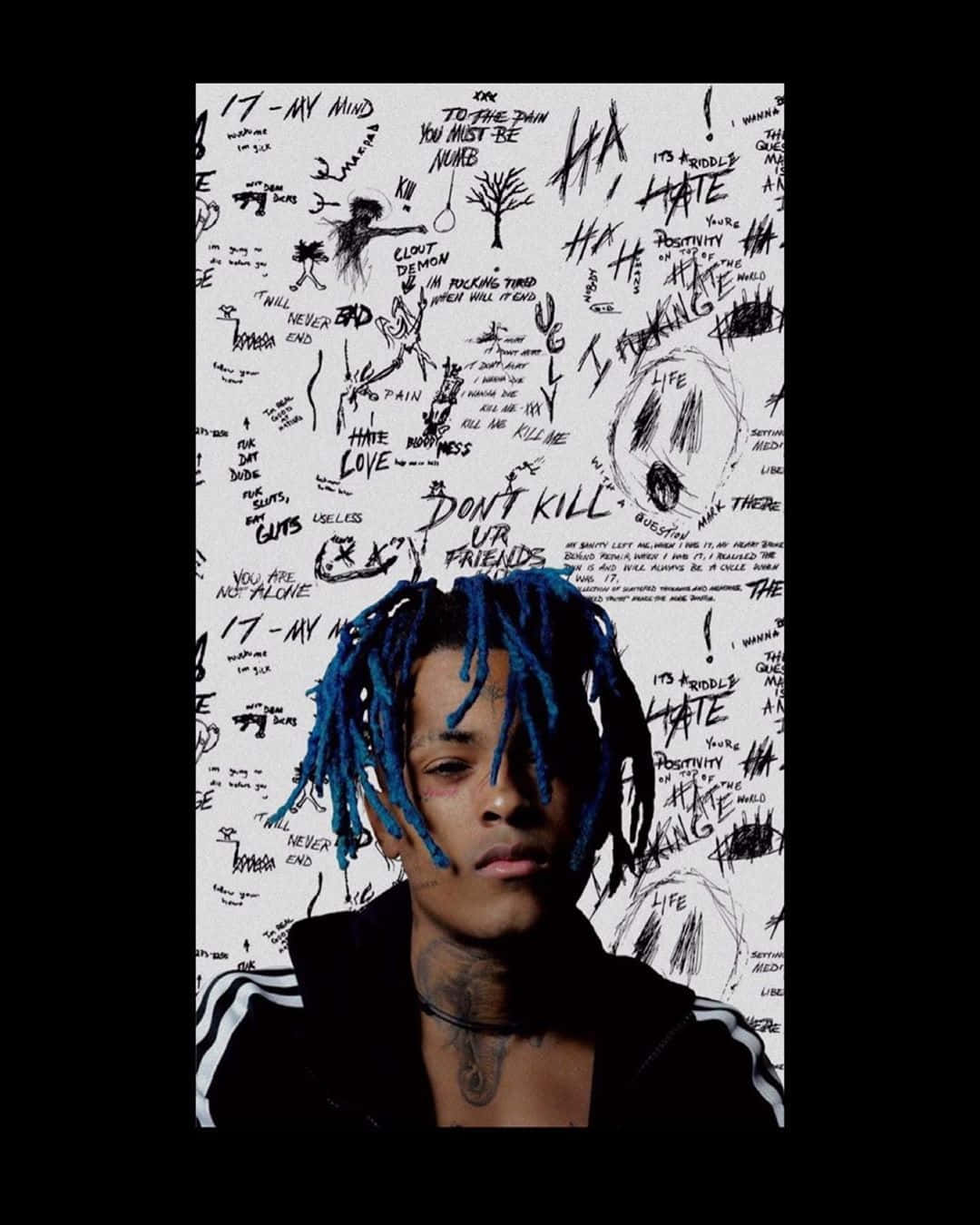 XXXTENTACION 桌布 壁紙 — 一名年輕男子留著藍色辮子，嚴肅地凝視著一面佈滿混亂黑色塗鴉和手寫短語的白牆。